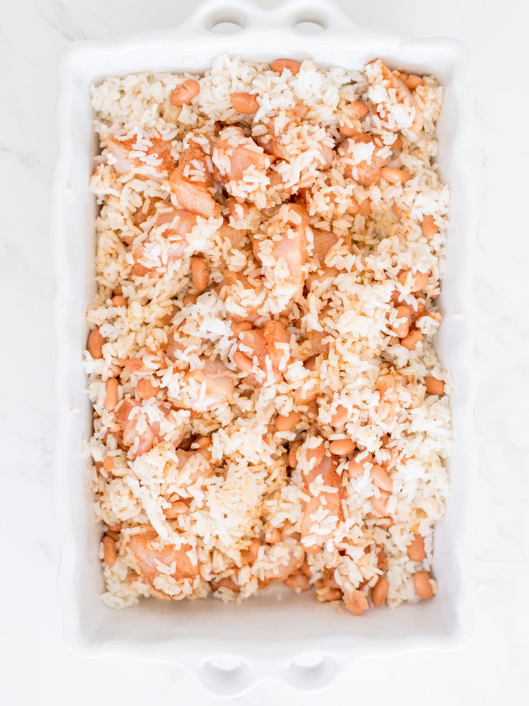 chicken rice and beans mixed together in baking dish