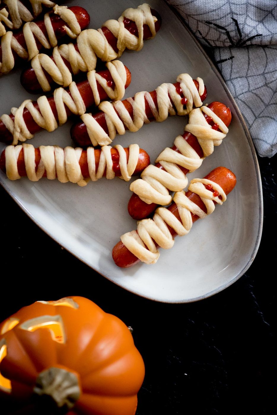 mummy pigs in a blanket on a serving tray