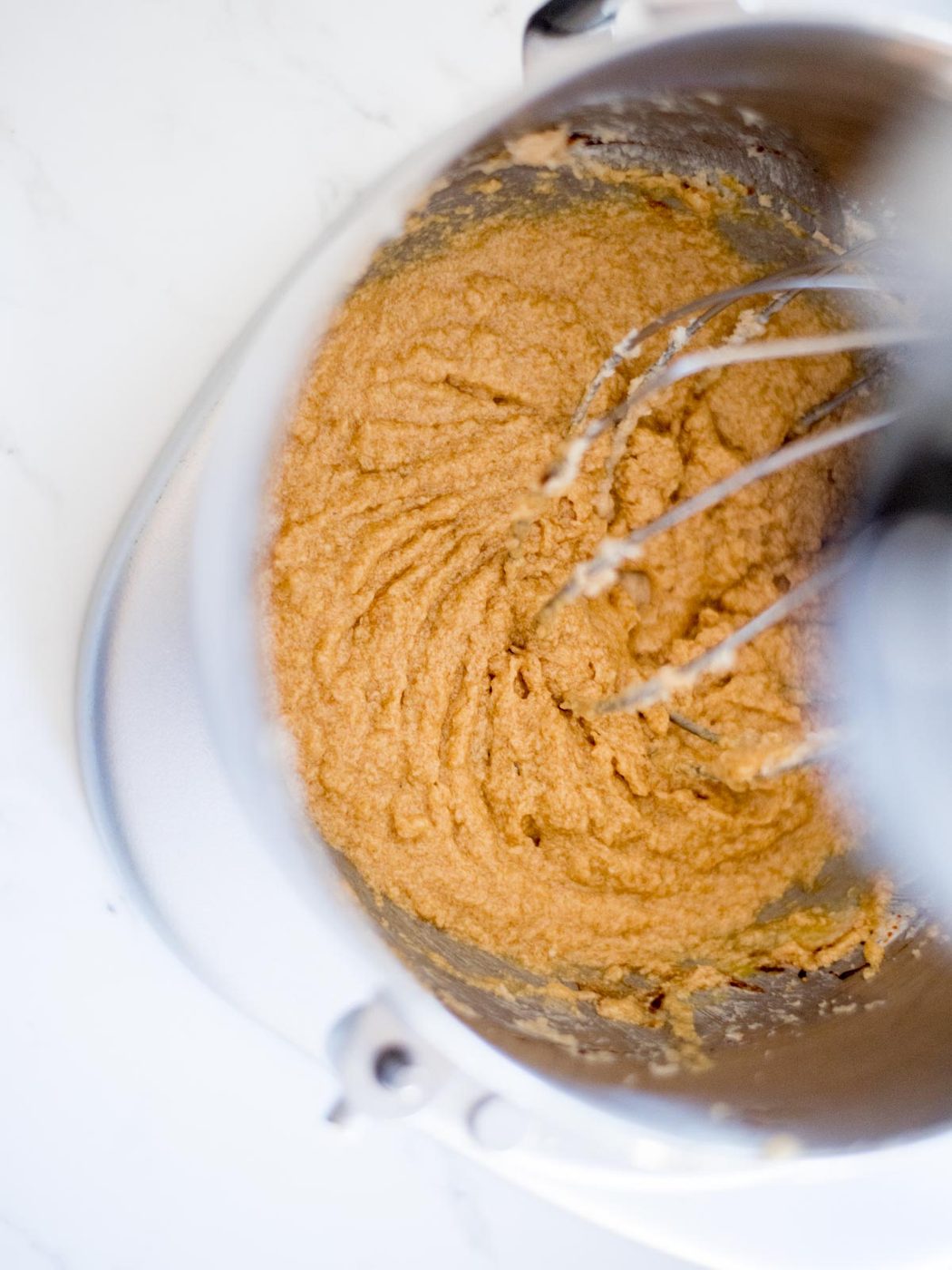 wet ingredients mixed with creamed butter and sugar in a mixing bowl
