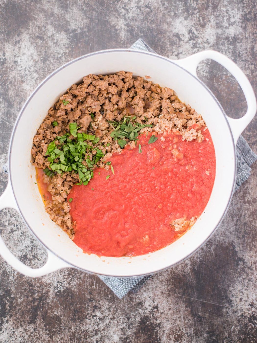 italian sausage crushed tomatoes oregano and basil in pot