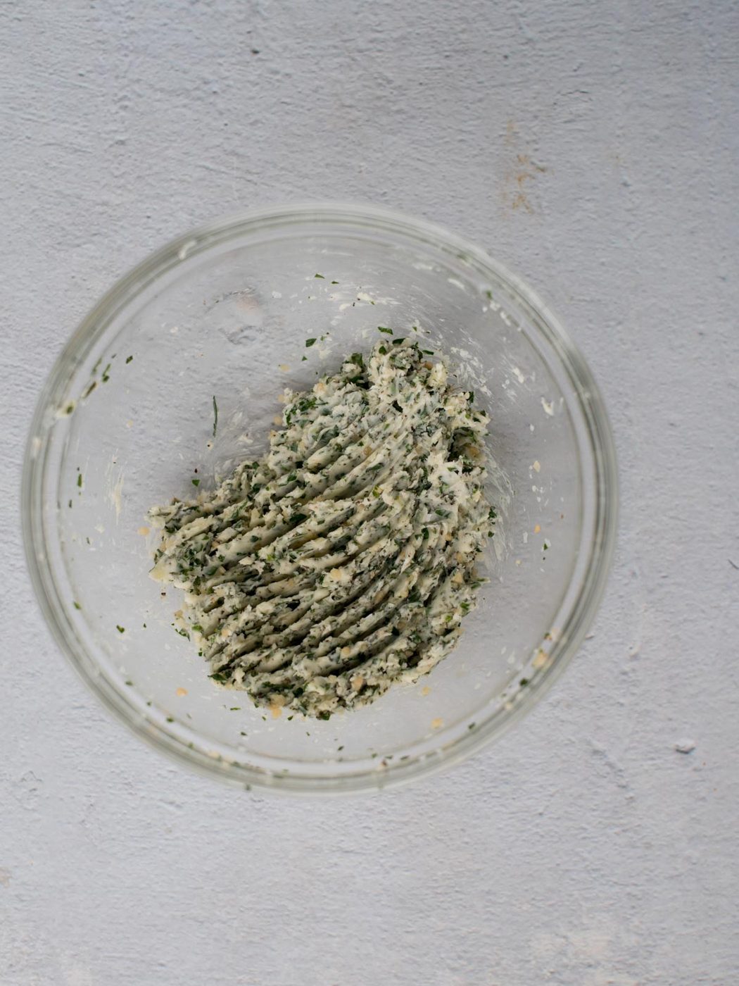 herbed butter mixed together in a glass mixing bowl