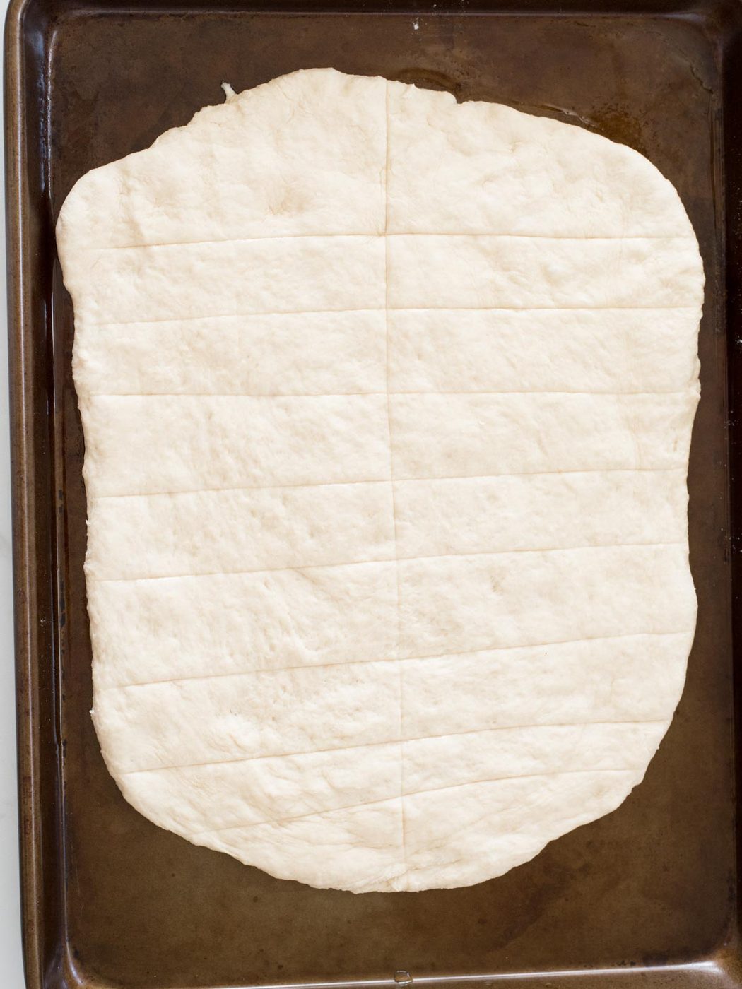 scored dough on a baking sheet
