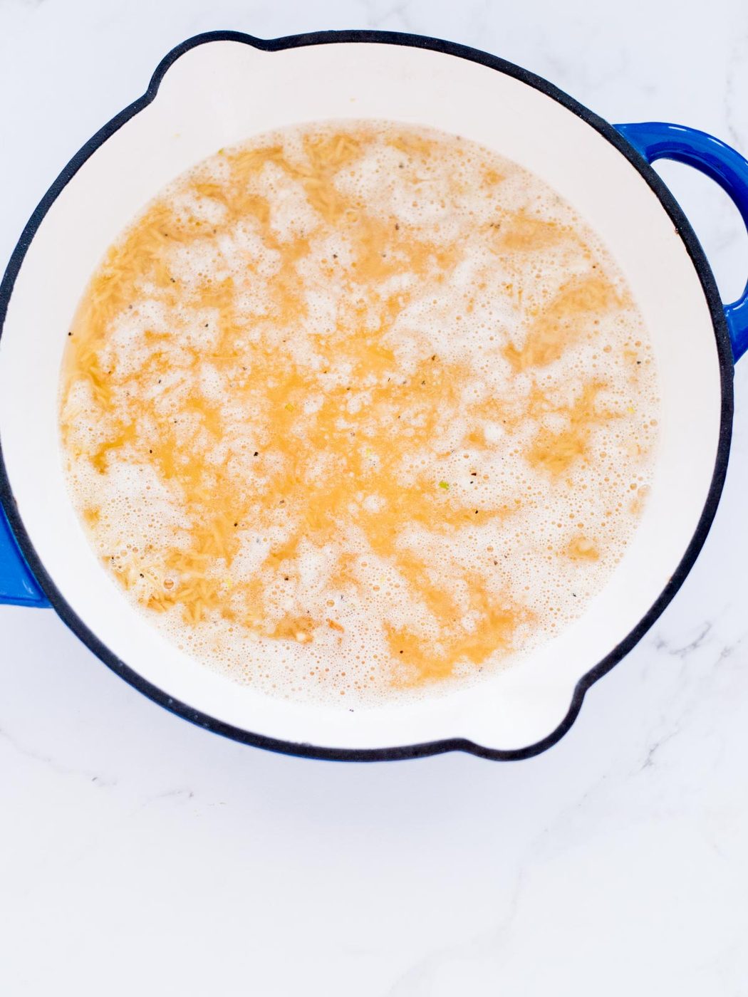 chicken broth poured into toasted orzo
