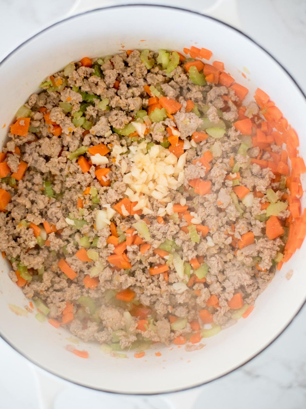 garlic added to dutch oven with sausage mix