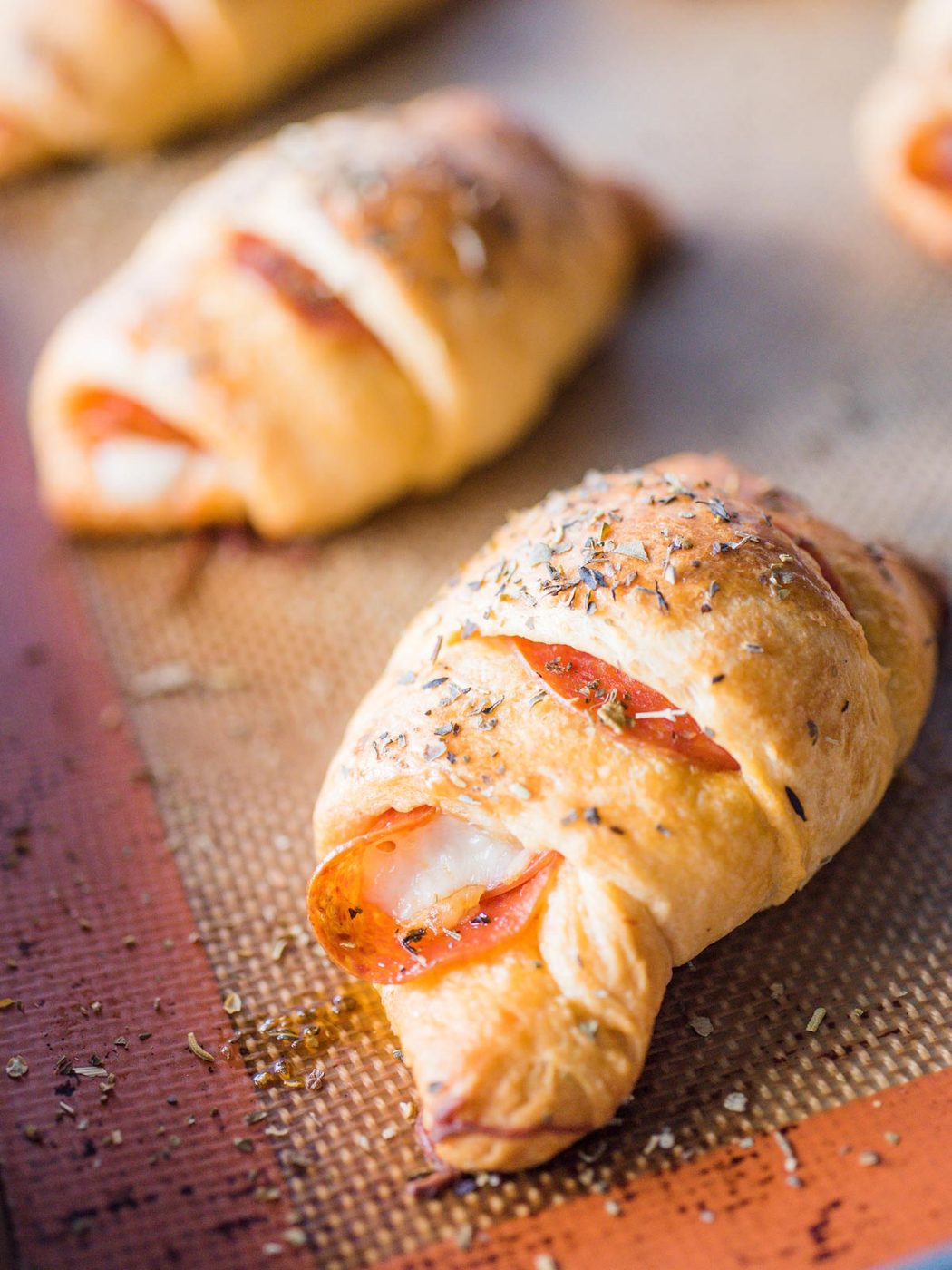 up close shot of pepperoni rolls on silicone lined baking sheet