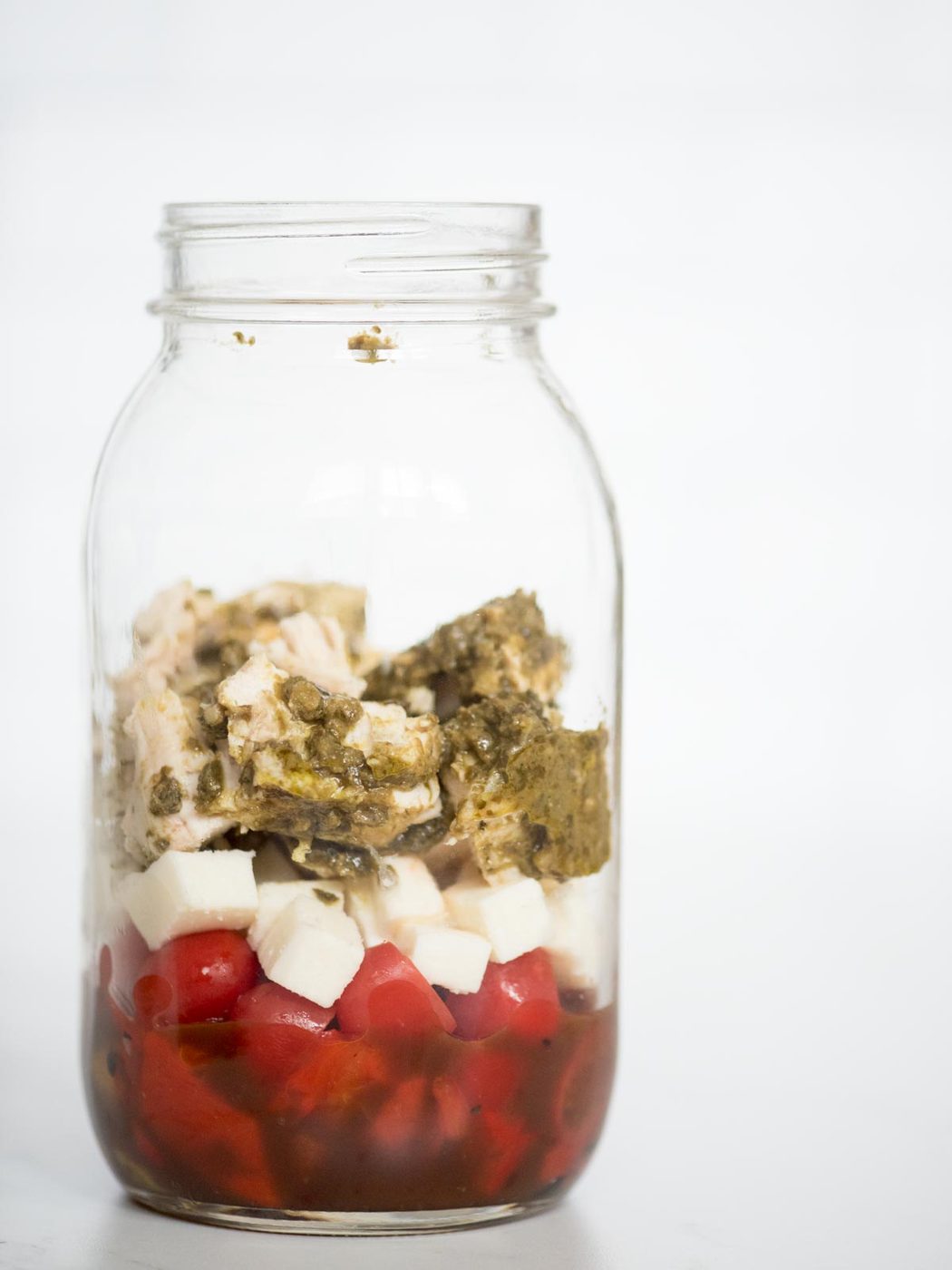 balsamic vinaigrette, roasted peppers, grape tomatoes, basil pesto chicken, and mozzarella in a jar