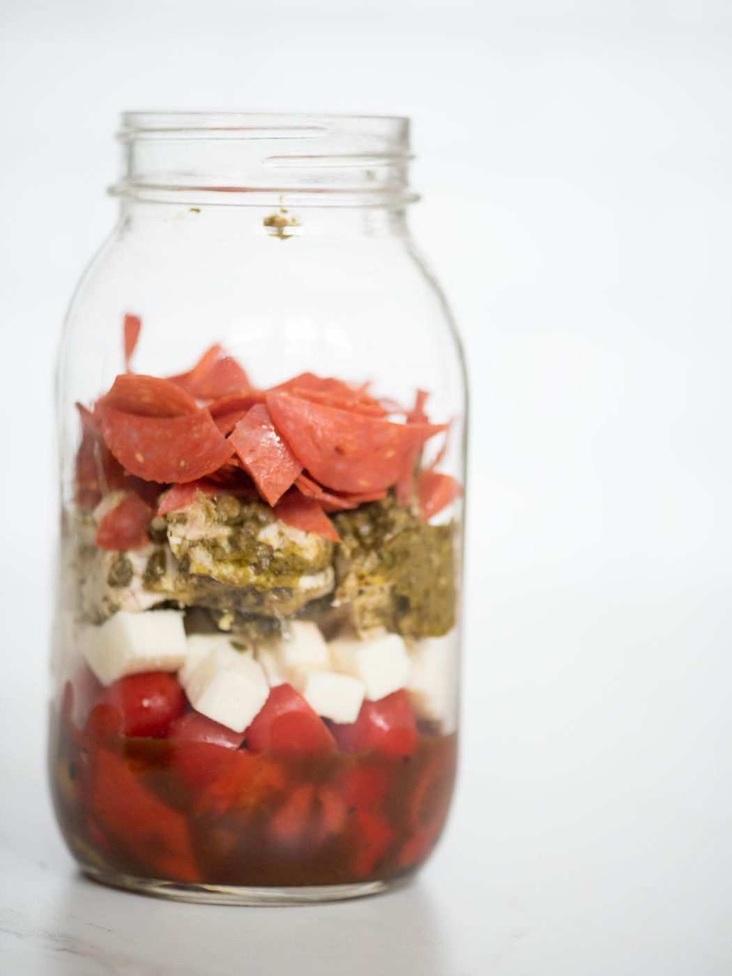 balsamic vinaigrette, roasted peppers, grape tomatoes, basil pesto chicken, pepperoni, and mozzarella in a jar