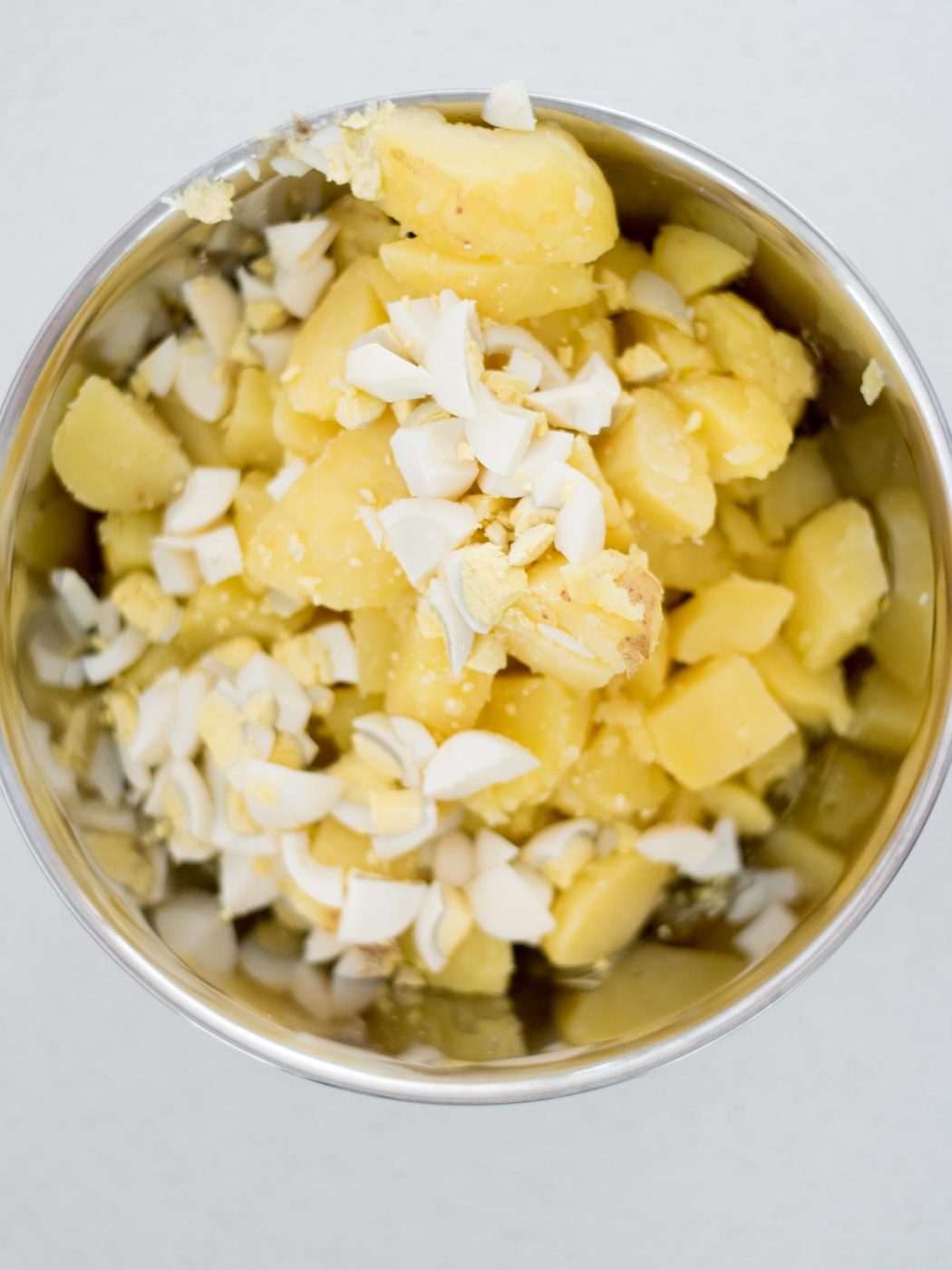 all ingredients of potato salad in a mixing bowl before mixing