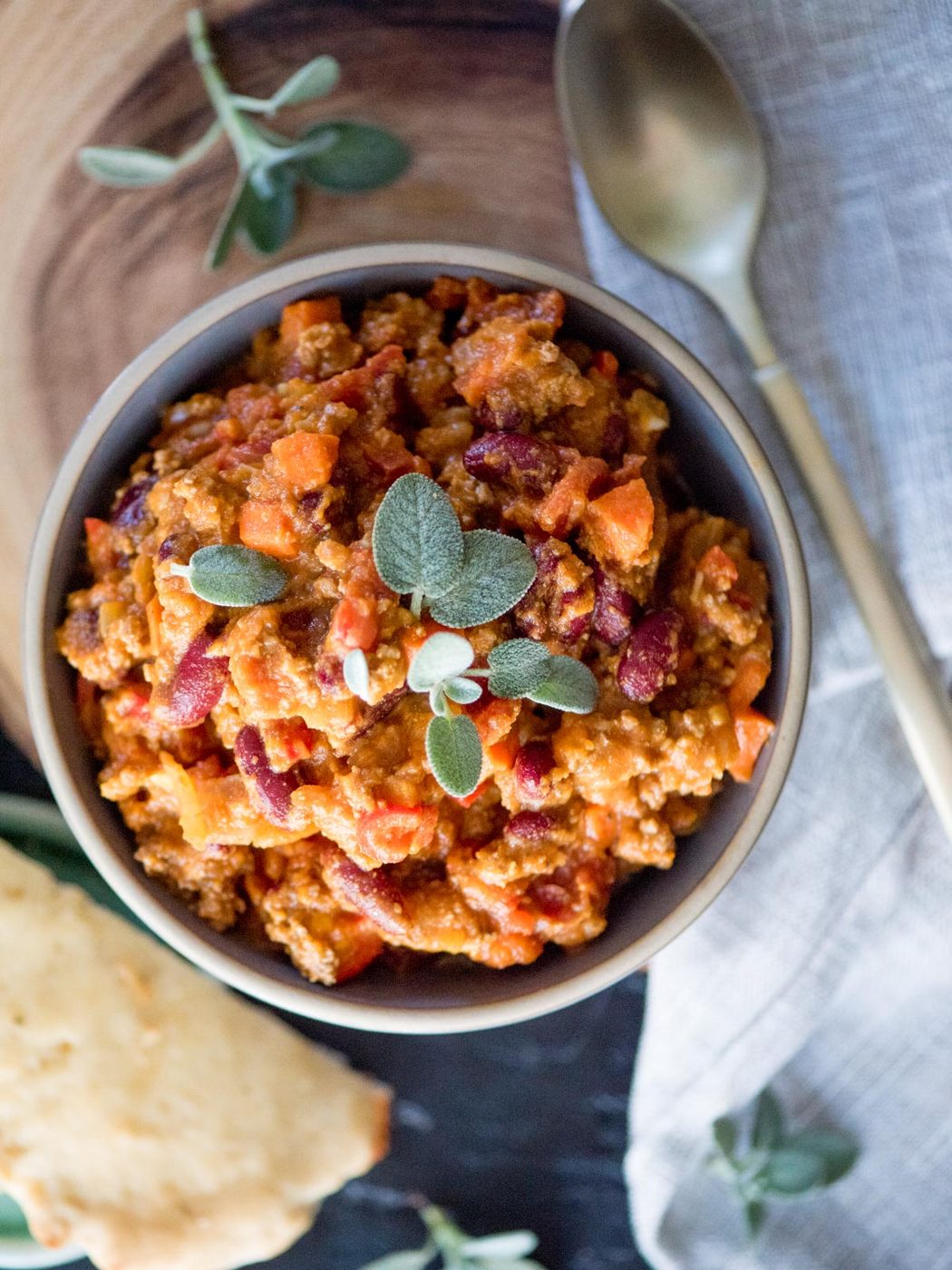 pumpkin chili in a bowl topped with fresh sage