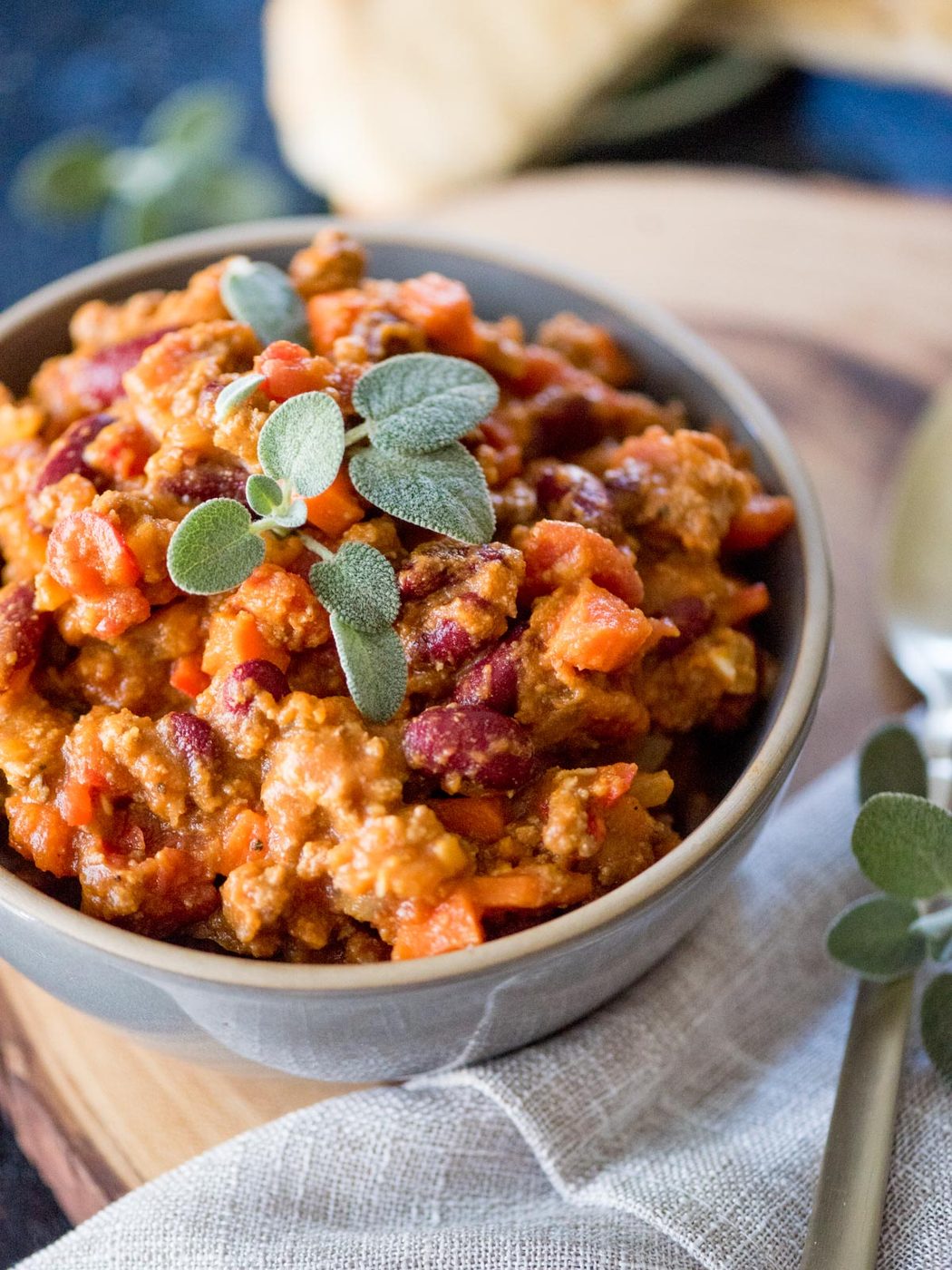 pumpkin chili in a bowl topped with fresh sage