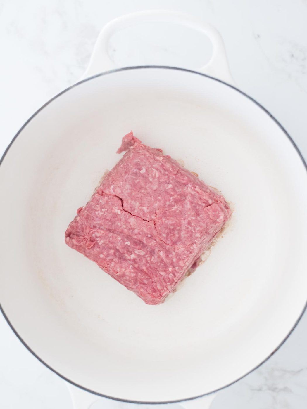 ground beef in an enamel cast iron dutch oven