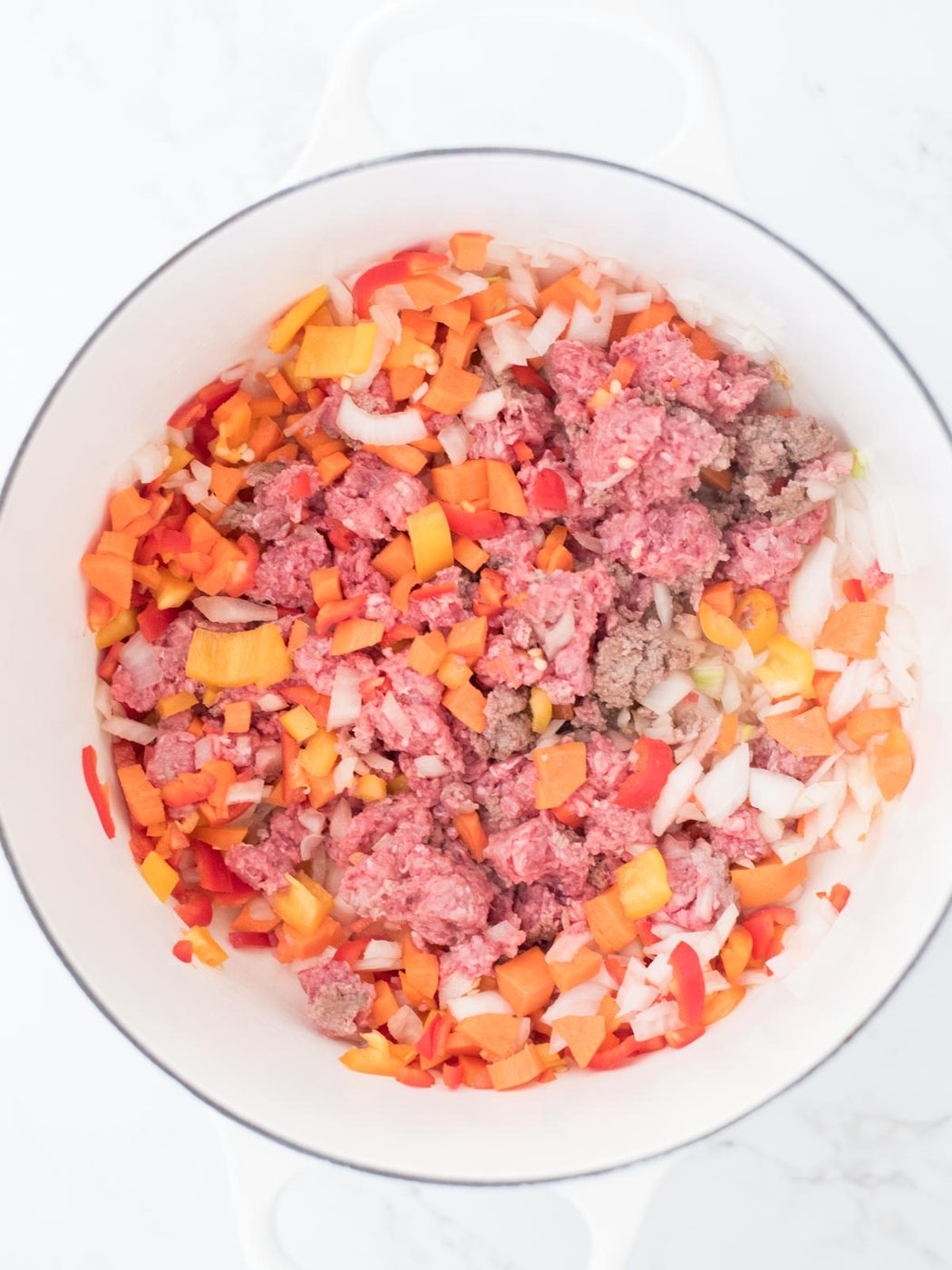 beef and vegetable mixture mixed together in the dutch oven