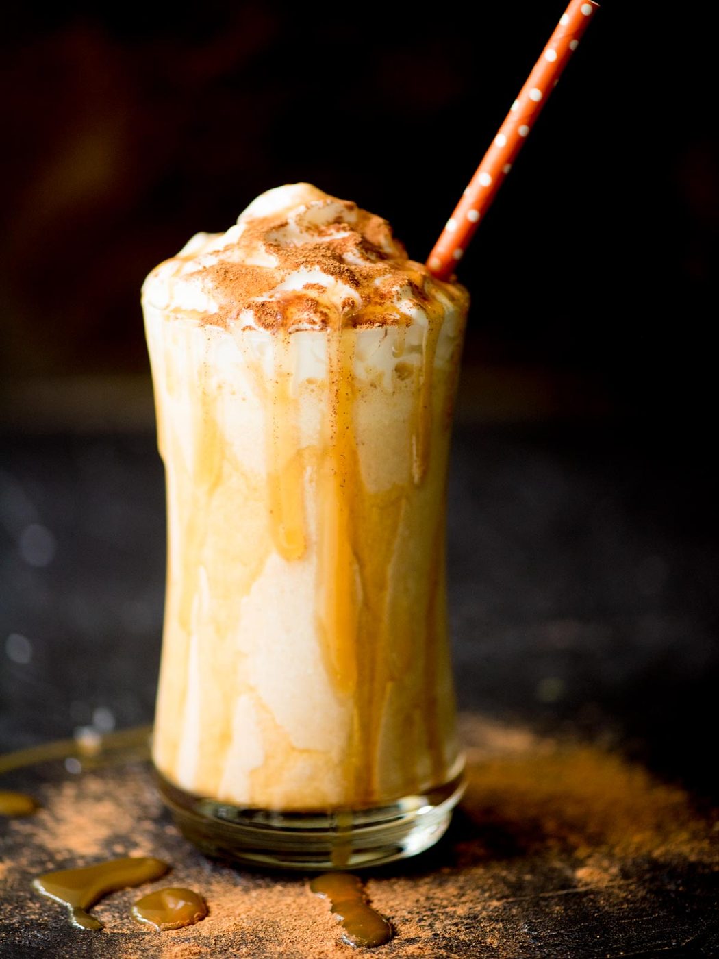 pumpkin milkshake in a glass with a caramel drizzle