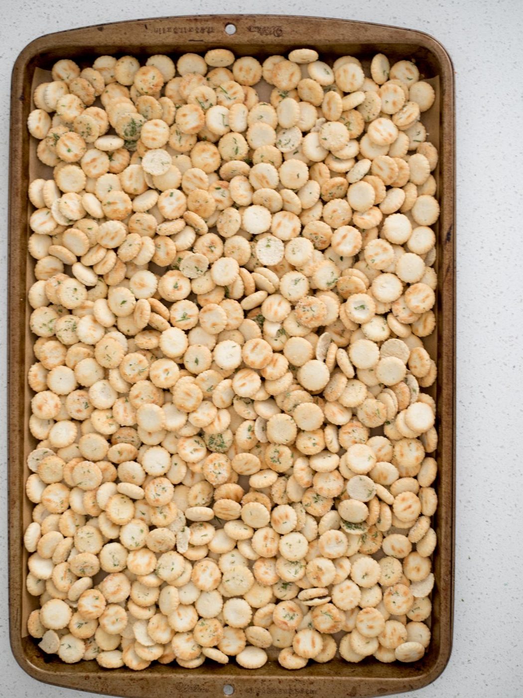 Baking sheet with seasoned oyster crackers on top.