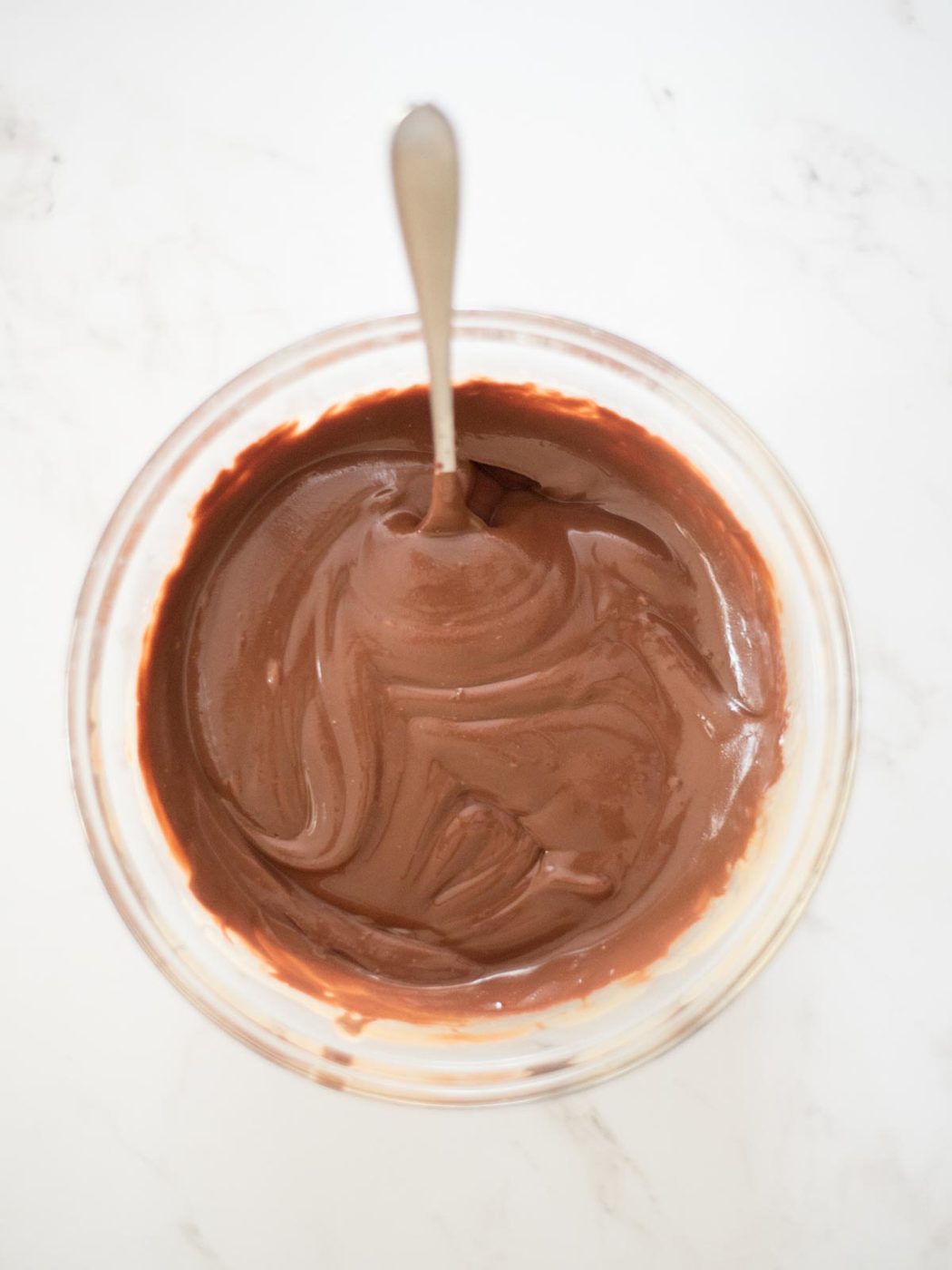 chocolate melted into the butter and peanut butter in a glass mixing bowl