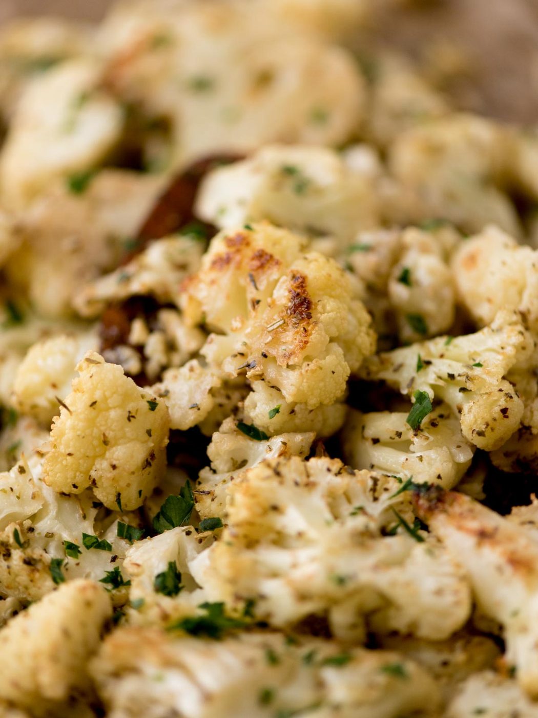 roasted cauliflower being scooped from a baking sheet