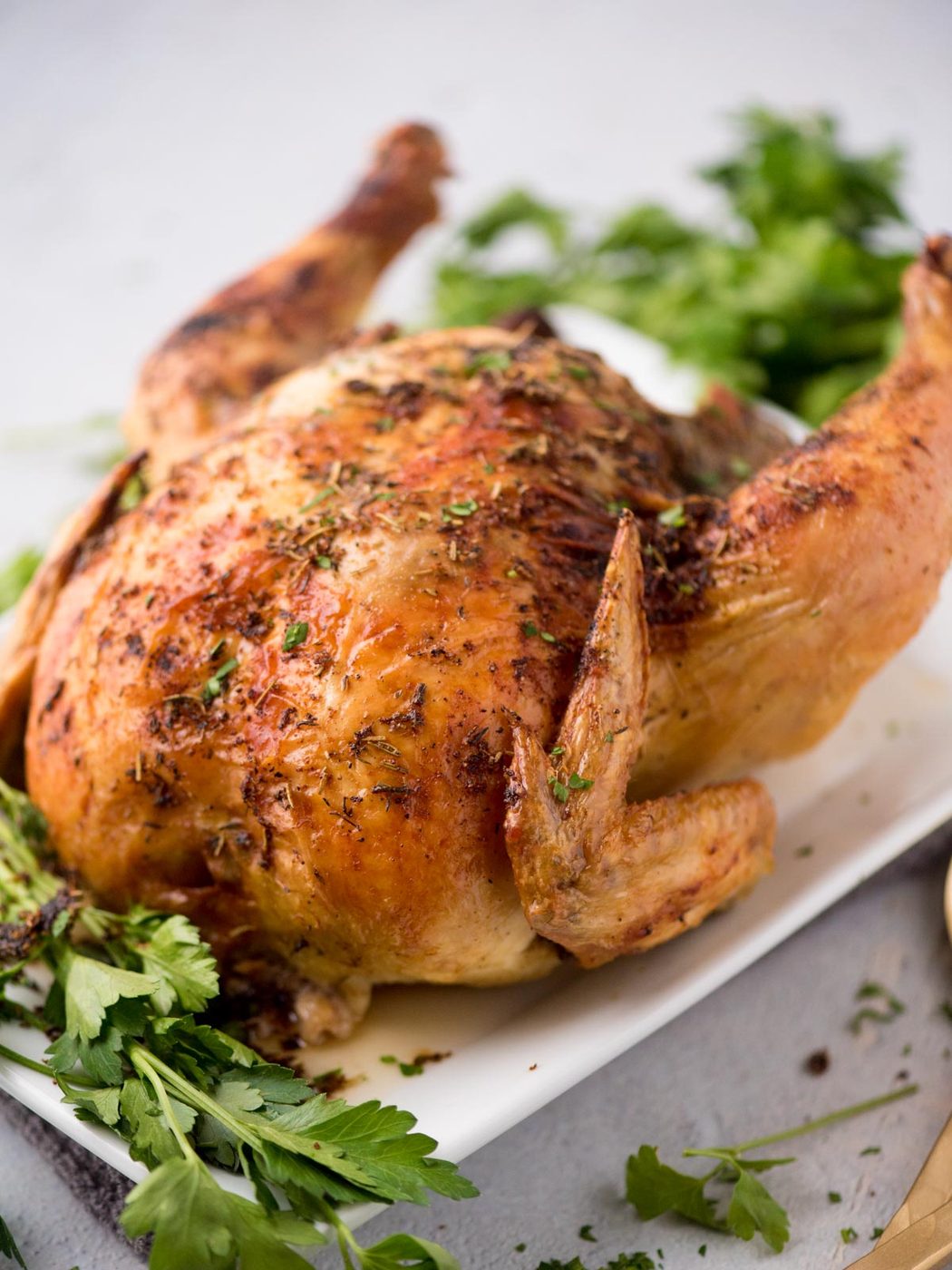 roasted chicken on a plate with fresh parsley