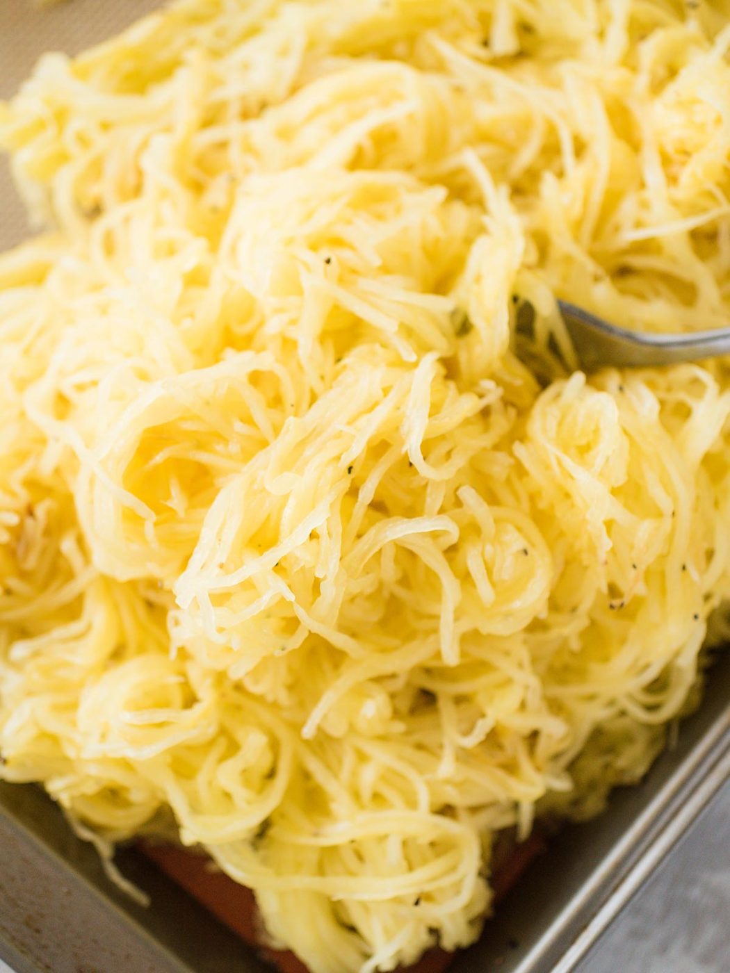 pile of roasted spaghetti squash on a baking sheet