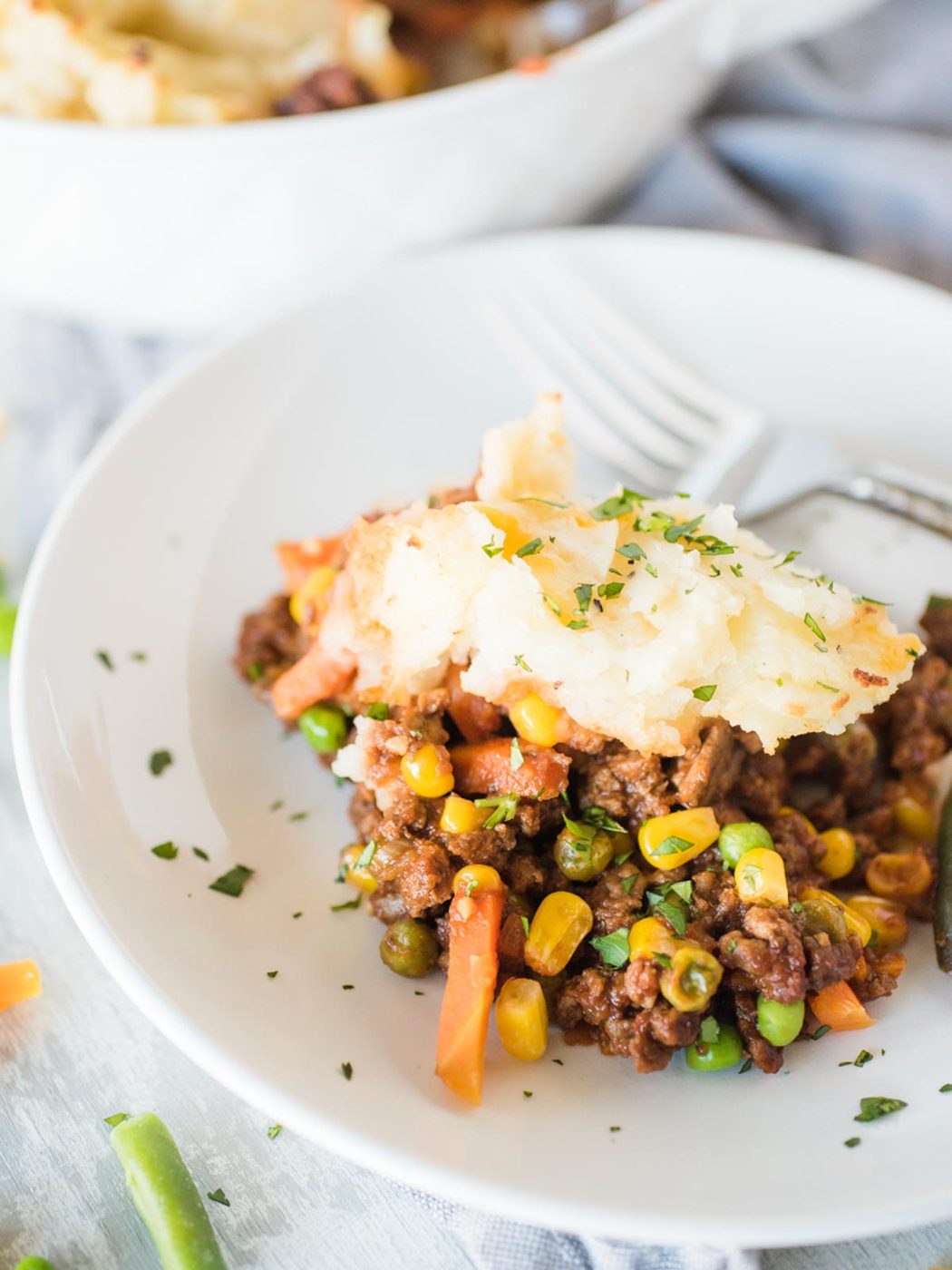 a serving of shepherds pie in a white shallow bowl