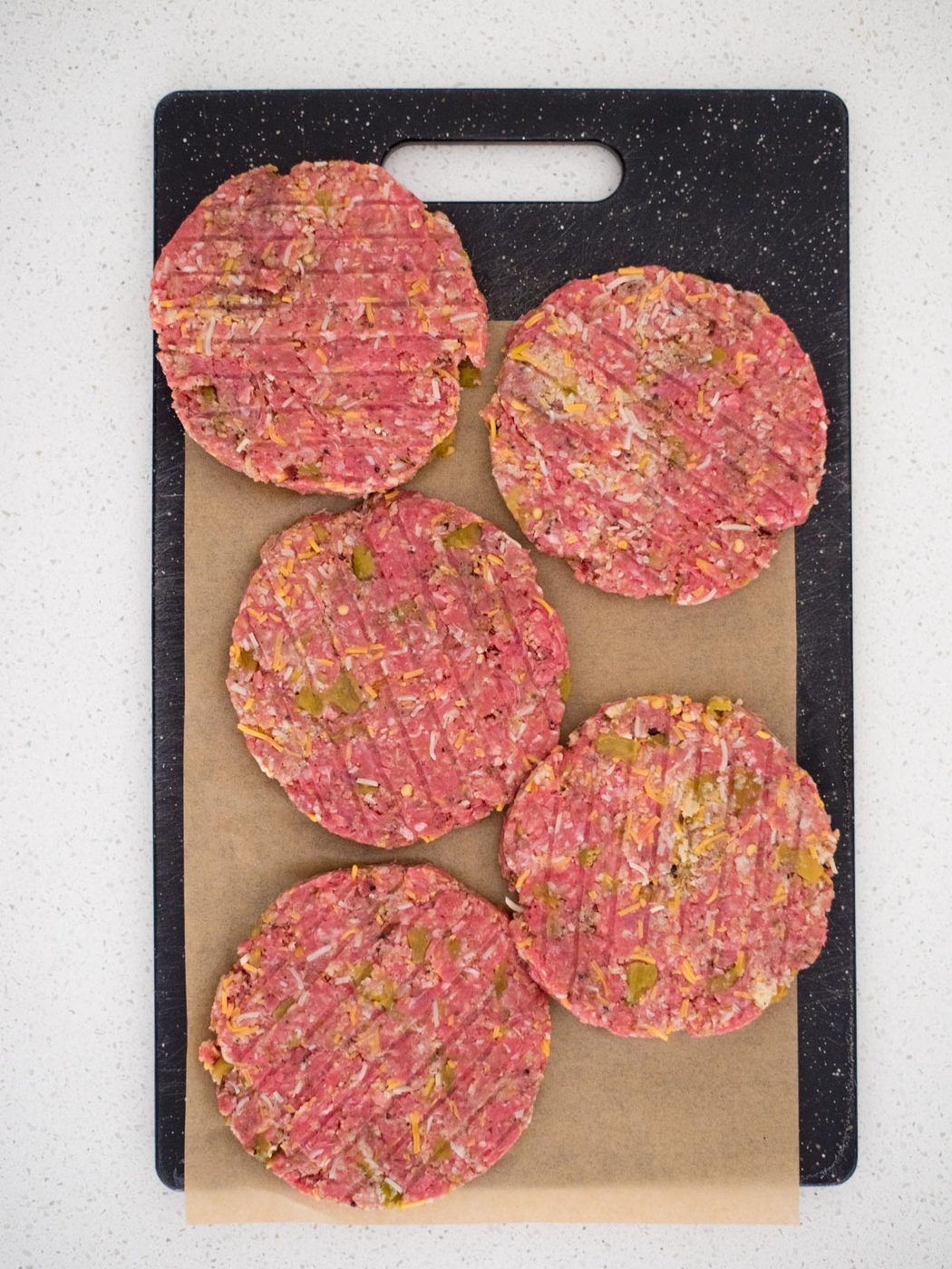 smoked burger patties on a cutting board with parchment paper
