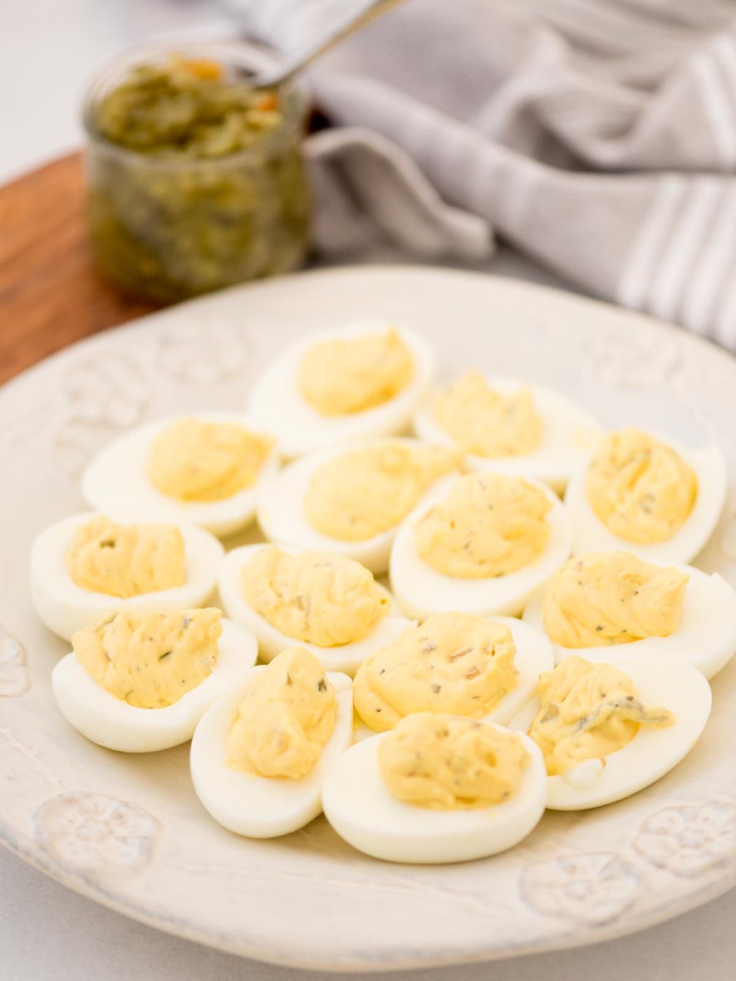 Creamy yolk mixture piped into egg whites sliced in half to make Southern Deviled eggs, served on a white platter.