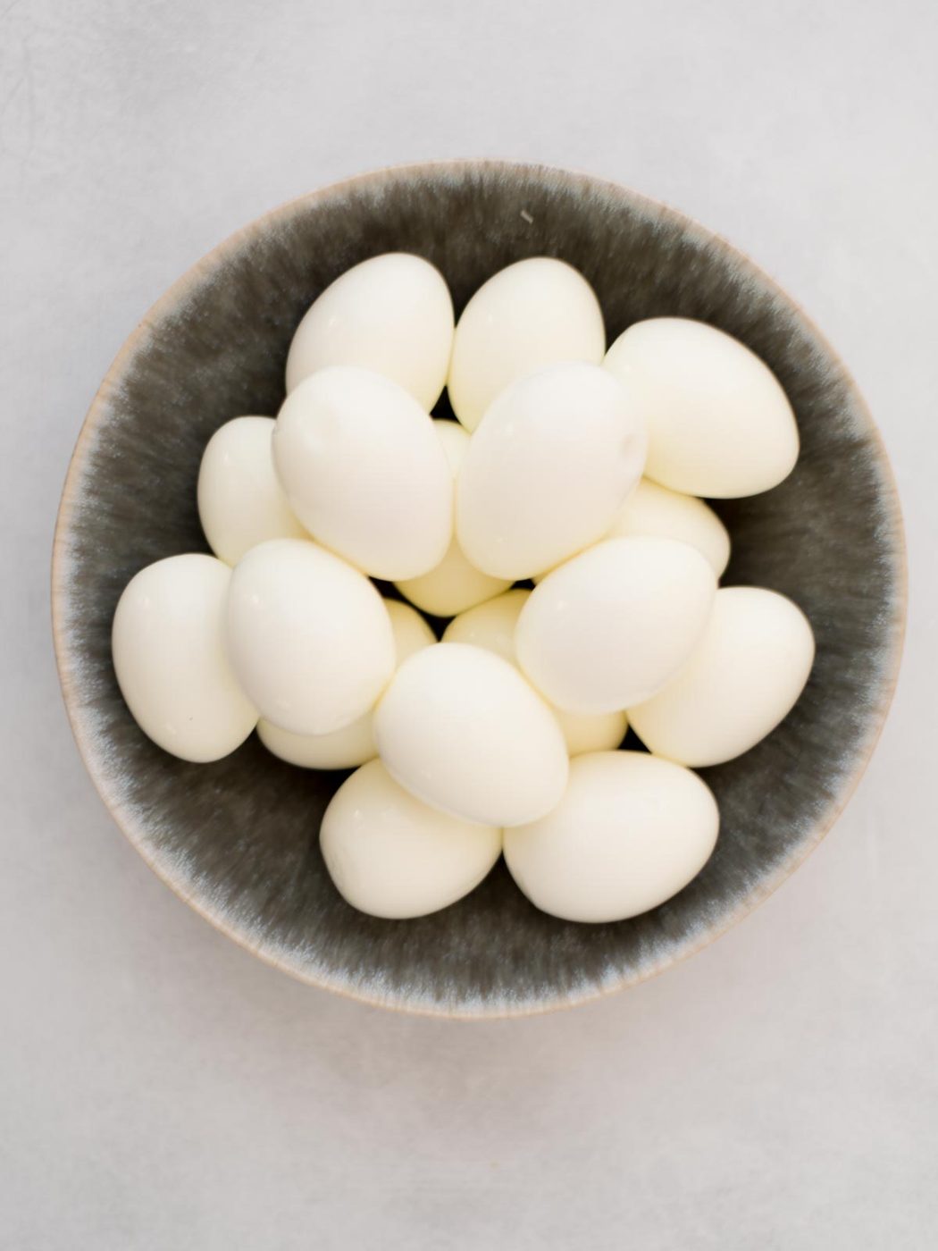 Shelled hardboiled eggs in a bowl.