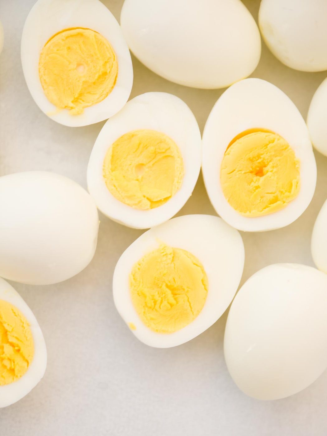 Hard boiled eggs cut in half, exposing the cooked yolks inside.