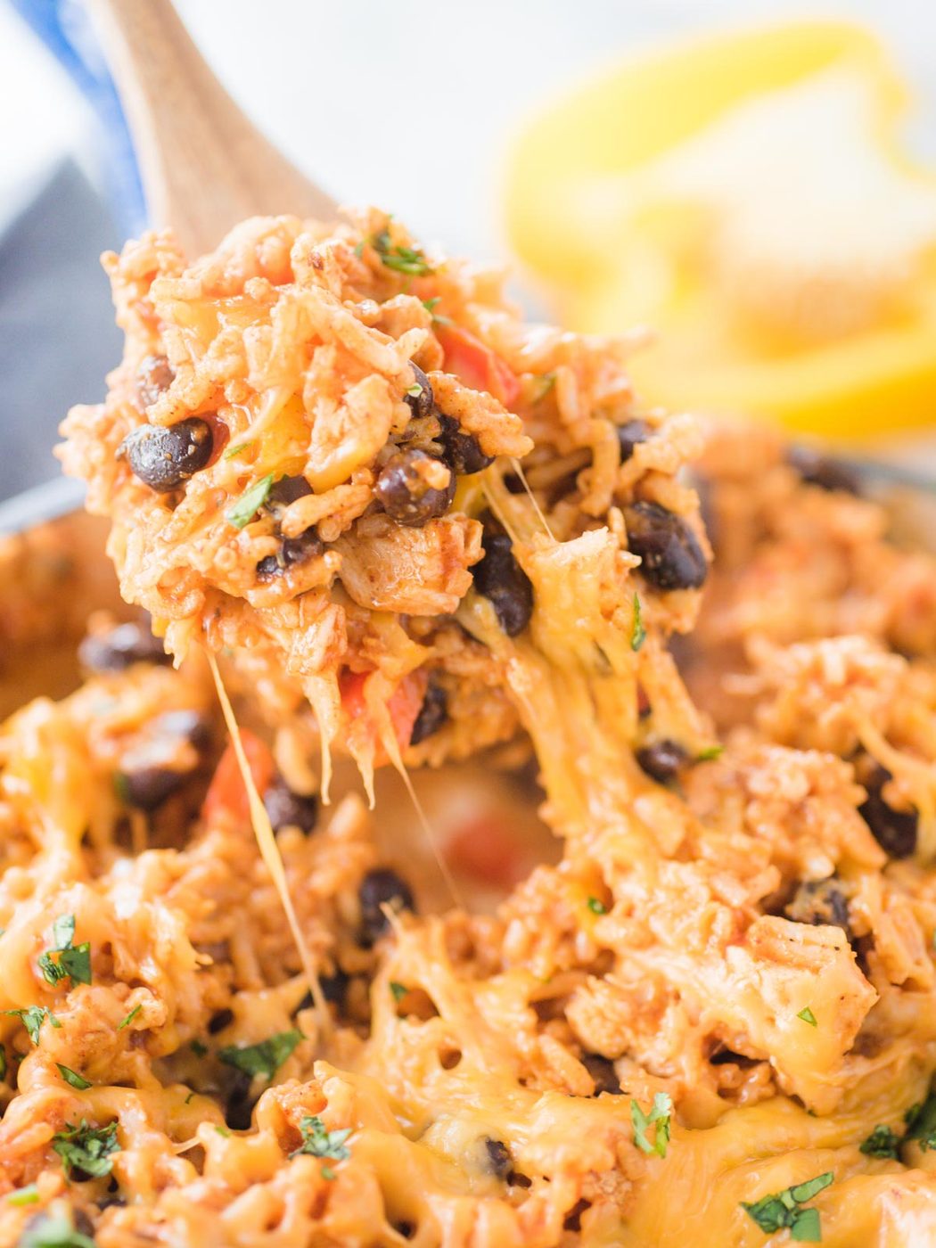Up close shot of southwest chicken and rice skillet being scooped with a wooden spoon.