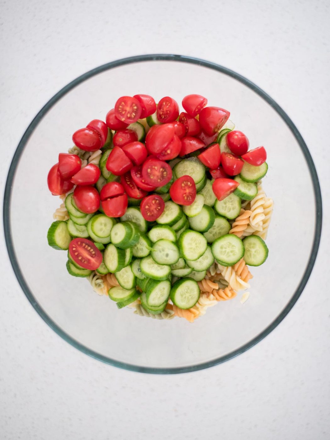 chopped vegetables in a mixing bowl with the cooked pasta