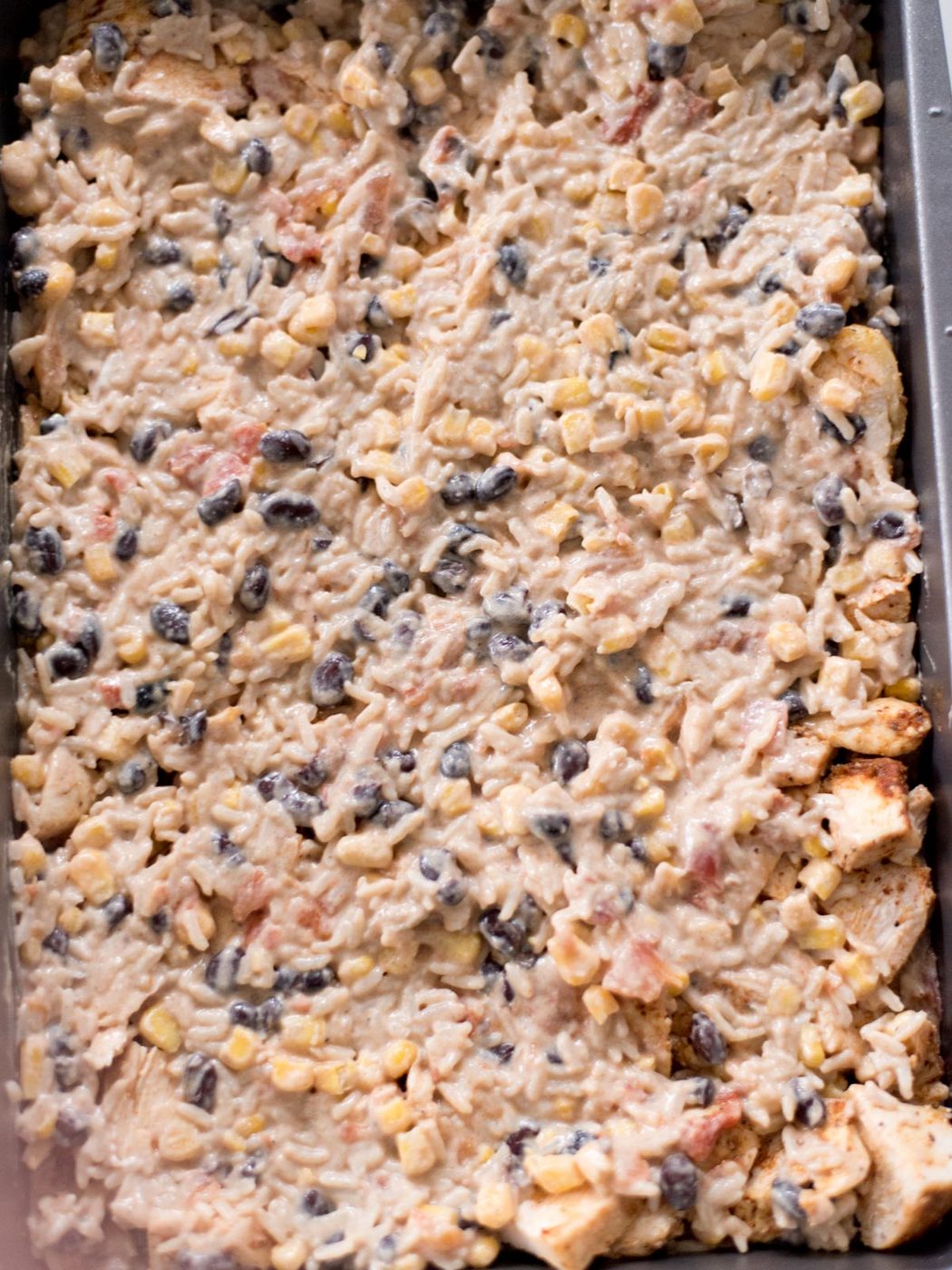 Final layer of rice mixture added over the seasoned chicken.
