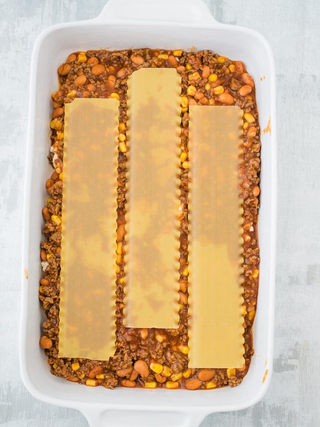 pasta noodle layer of tex mex lasagna in casserole dish