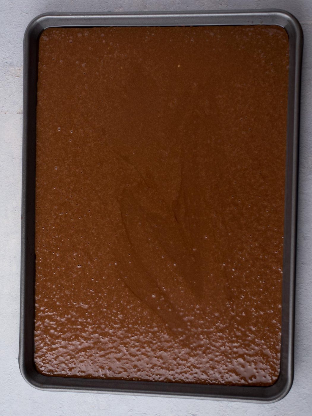 Unbaked texas sheet cake in a baking sheet