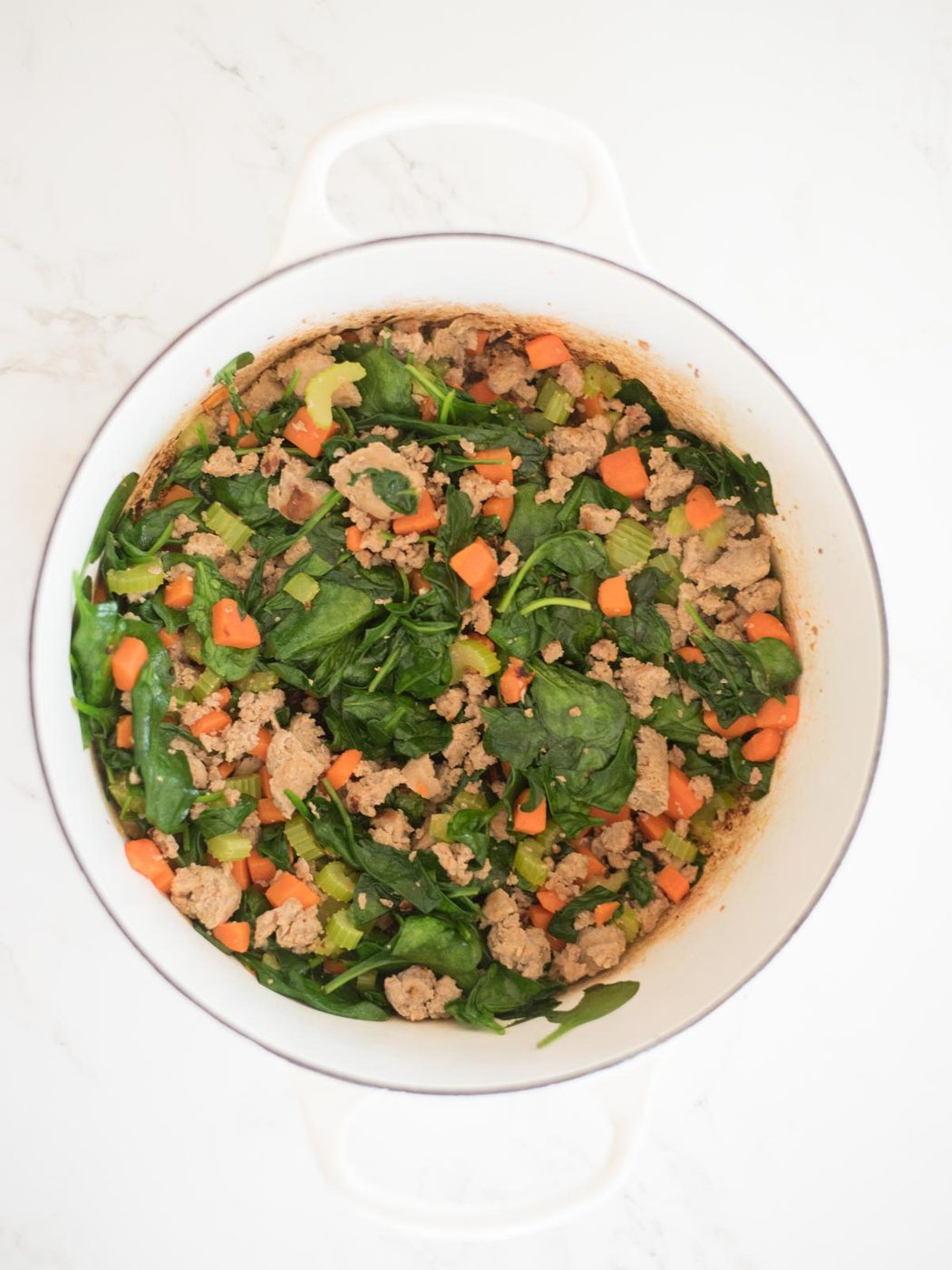 meat and vegetables sautéed in a dutch oven with spinach for tortellini soup