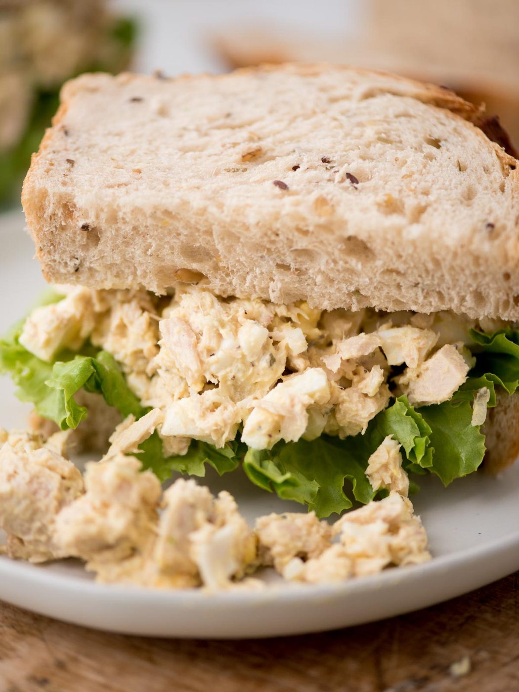 Close up of a half tuna salad sandwich served on a plate.