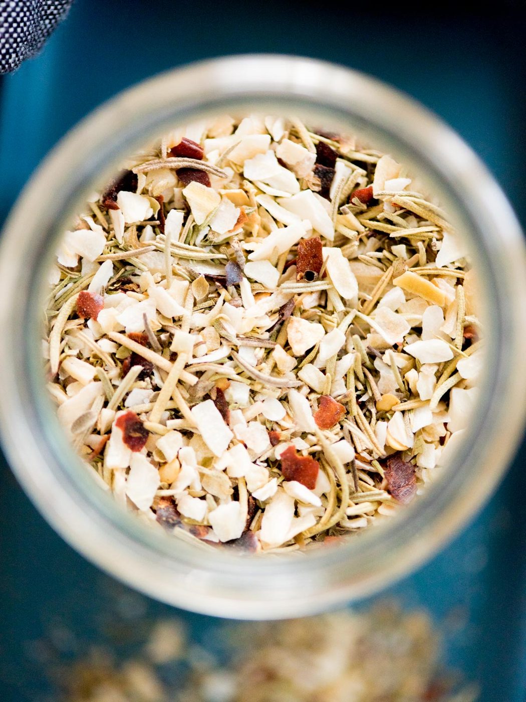 tuscan herb seasoning blend in a jar with a measuring spoon and plate