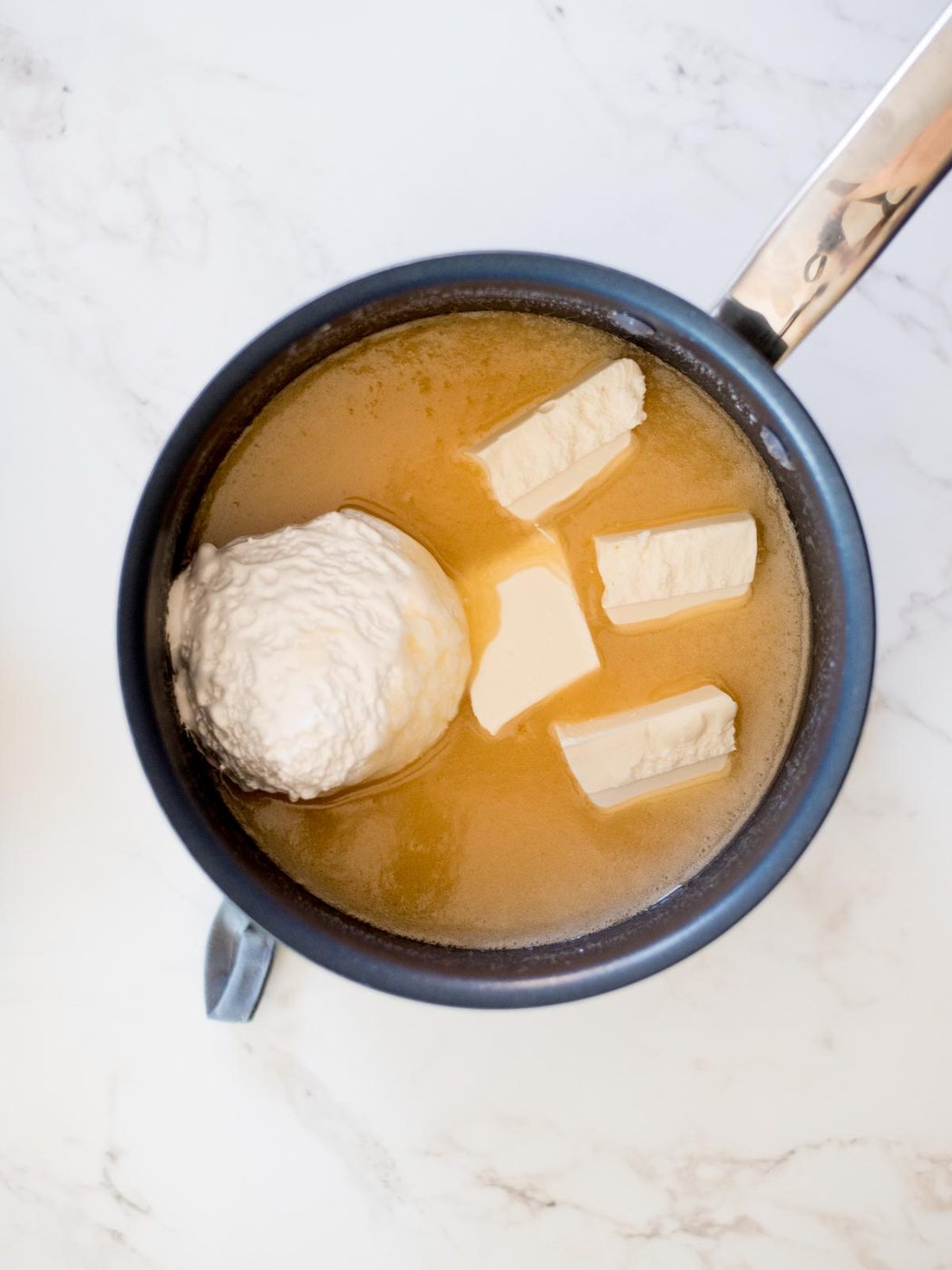 marshmallow cream and almond bark added to butter, sugar, and evaporated milk for vanilla fudge