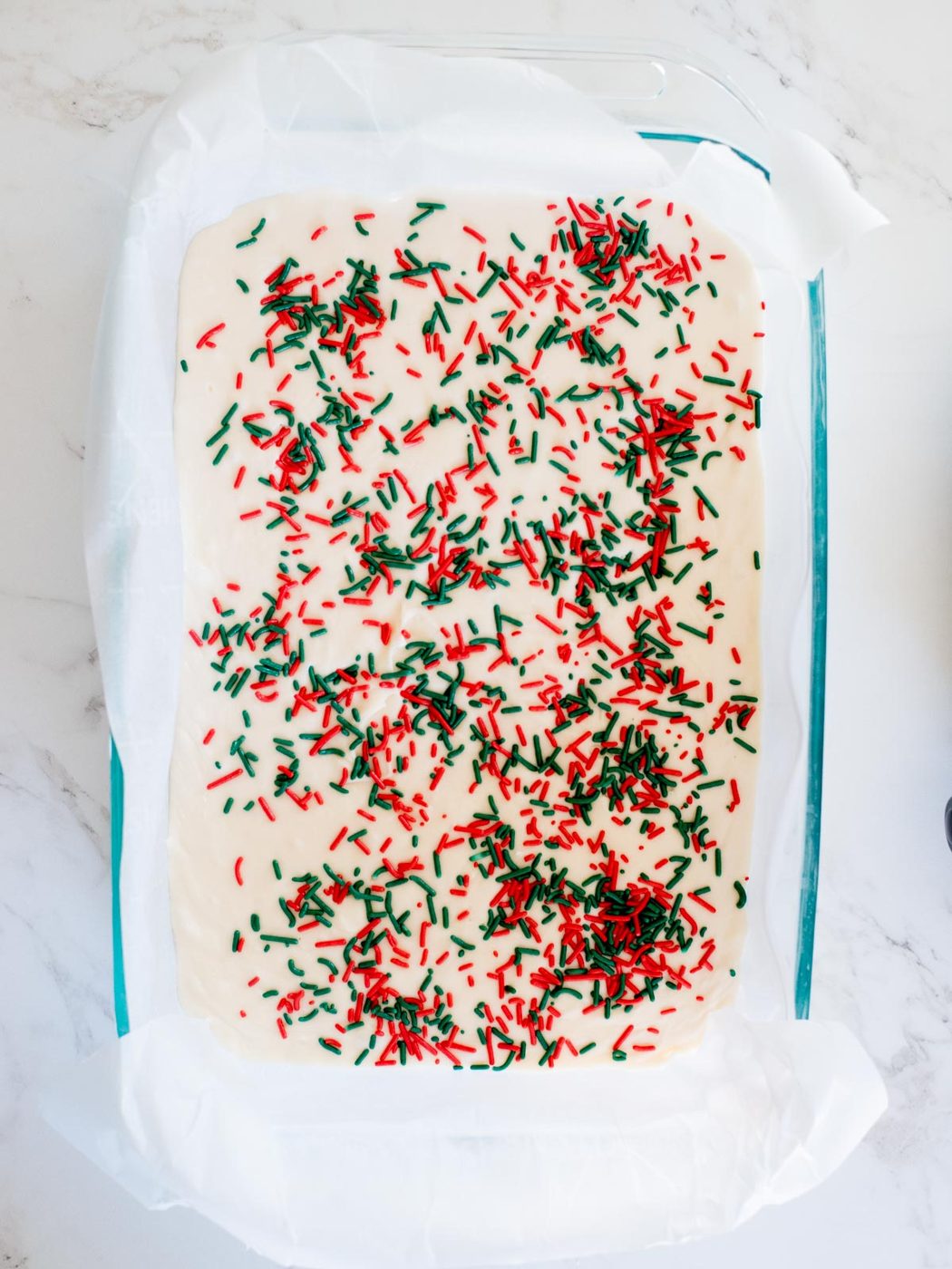 from-scratch vanilla fudge with sprinkles in a glass 9x13 pan