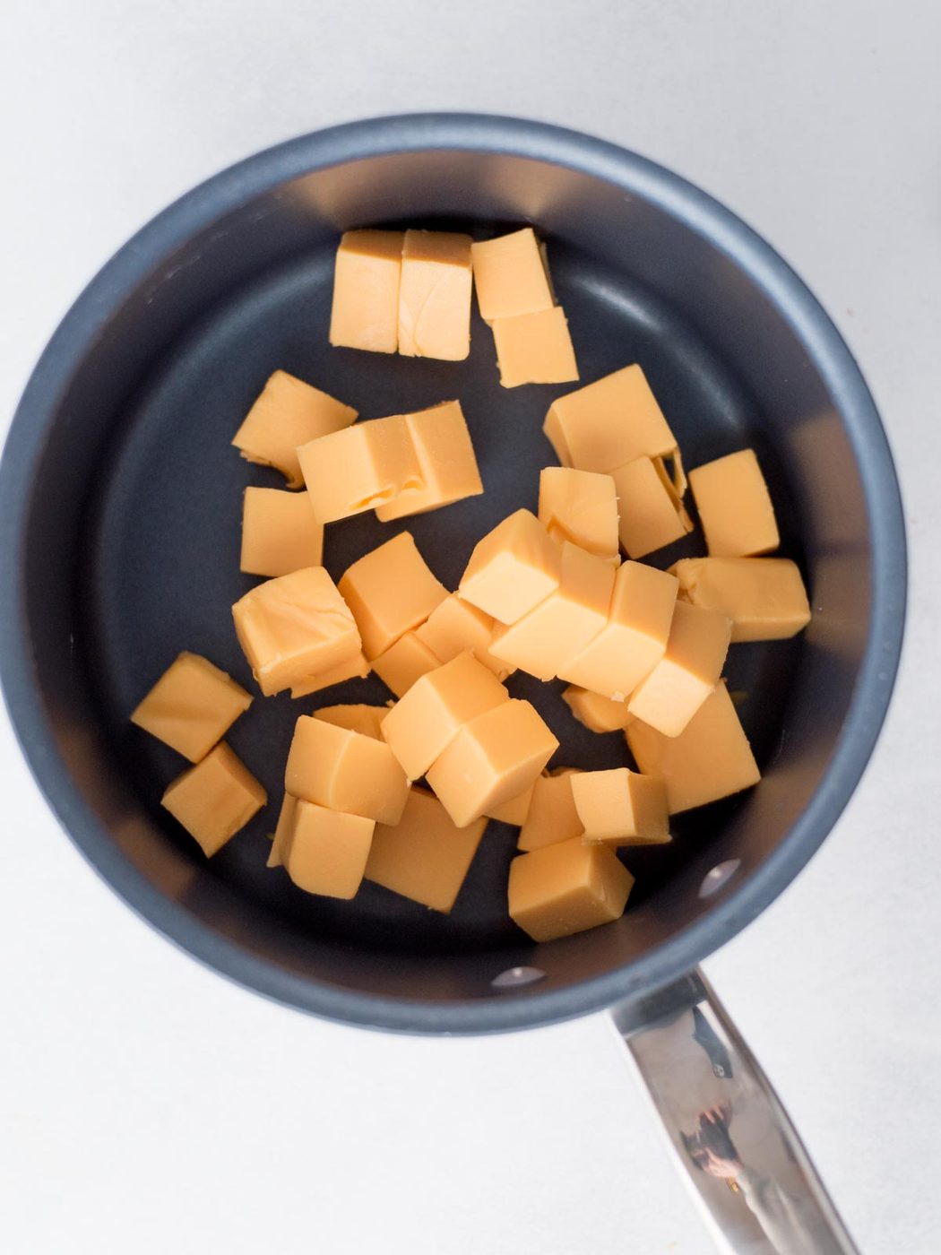 cubed velveeta in a pan.