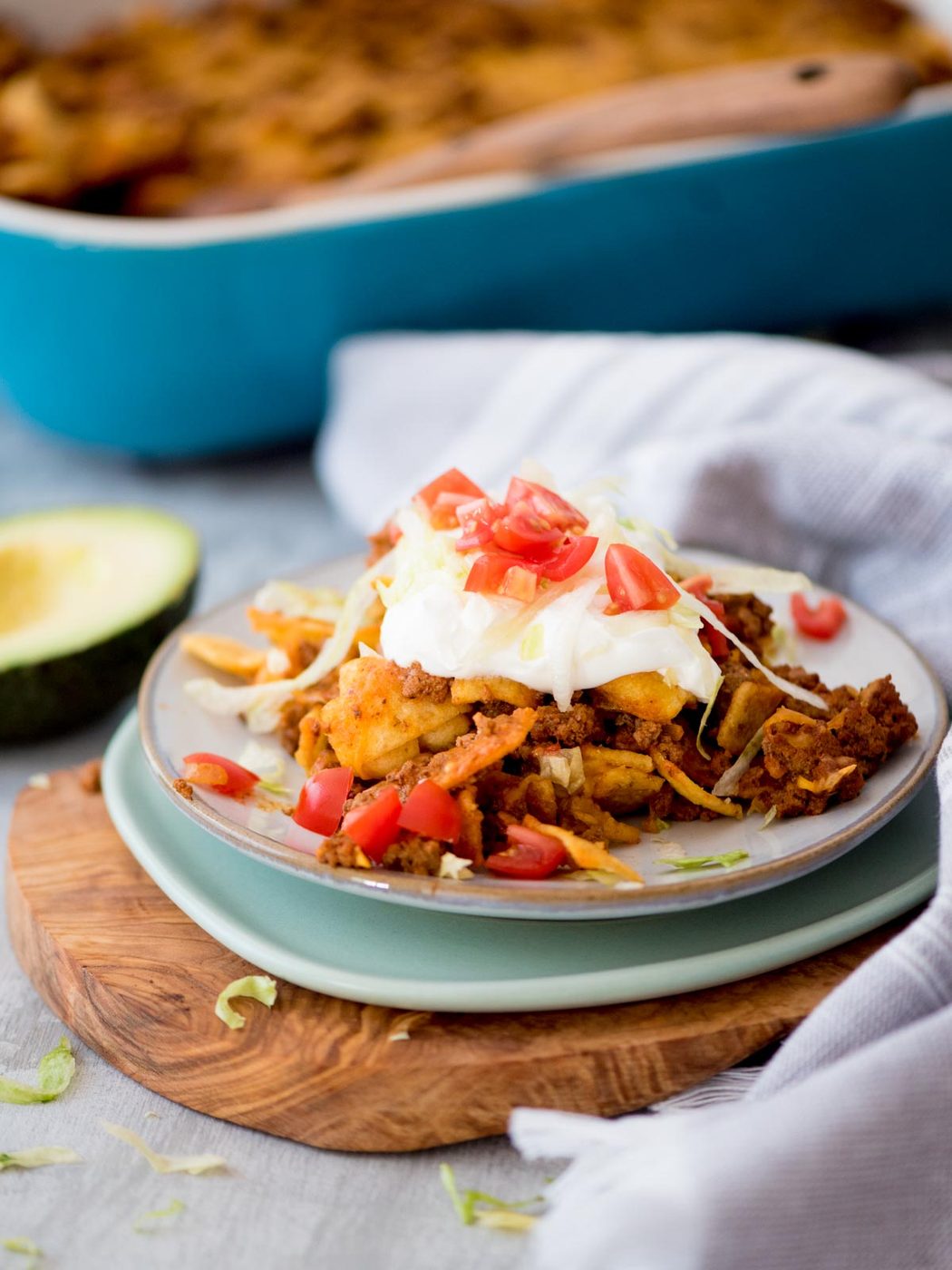 a walking taco plated and served with sour cream and diced tomatoes