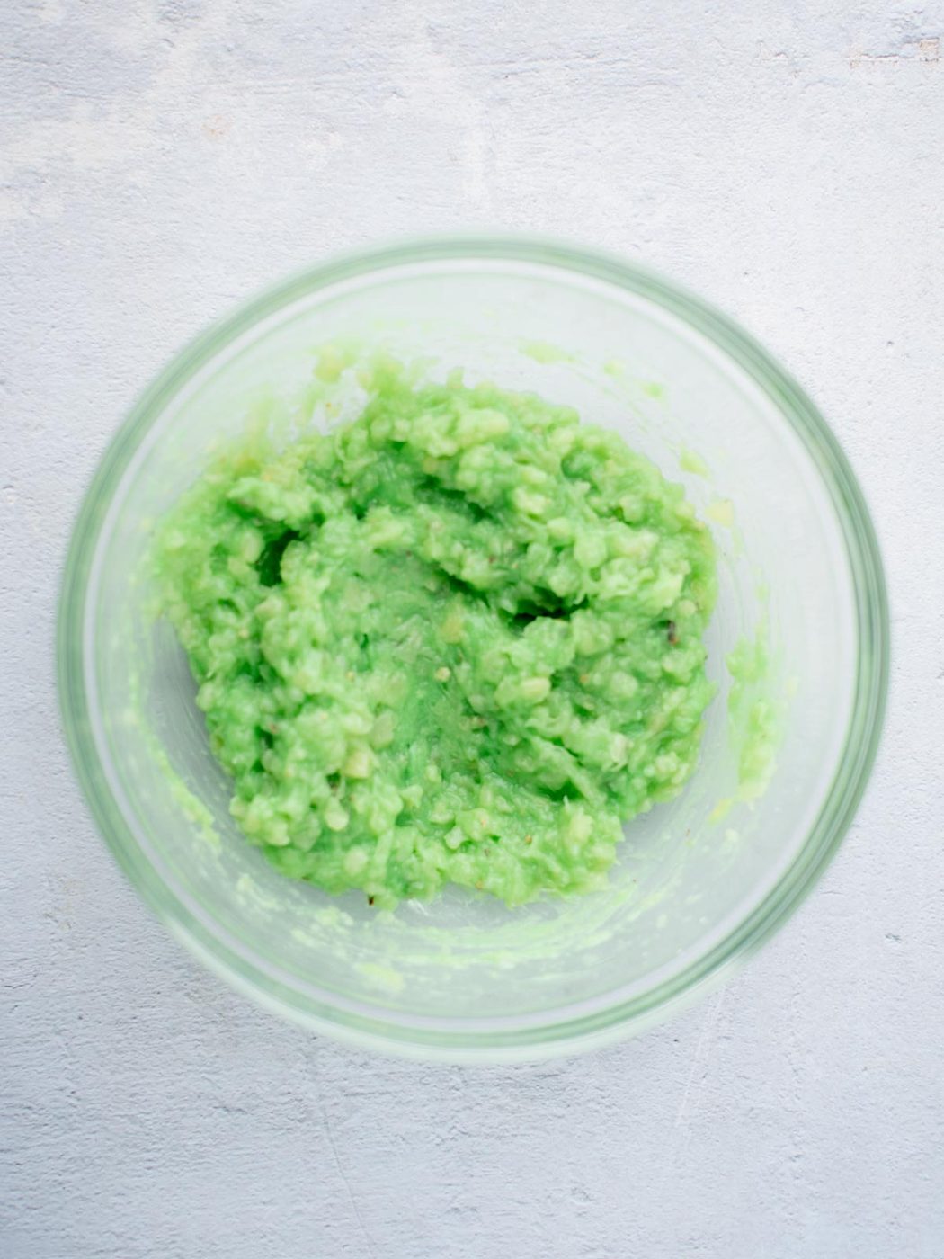 pistachio pudding mix combined with crushed pineapple in a mixing bowl