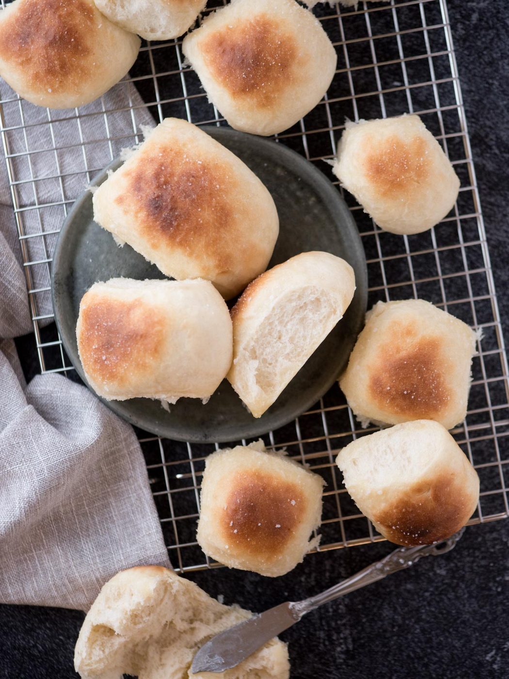 from-scratch yeast rolls on a cooling rack with a dish towel