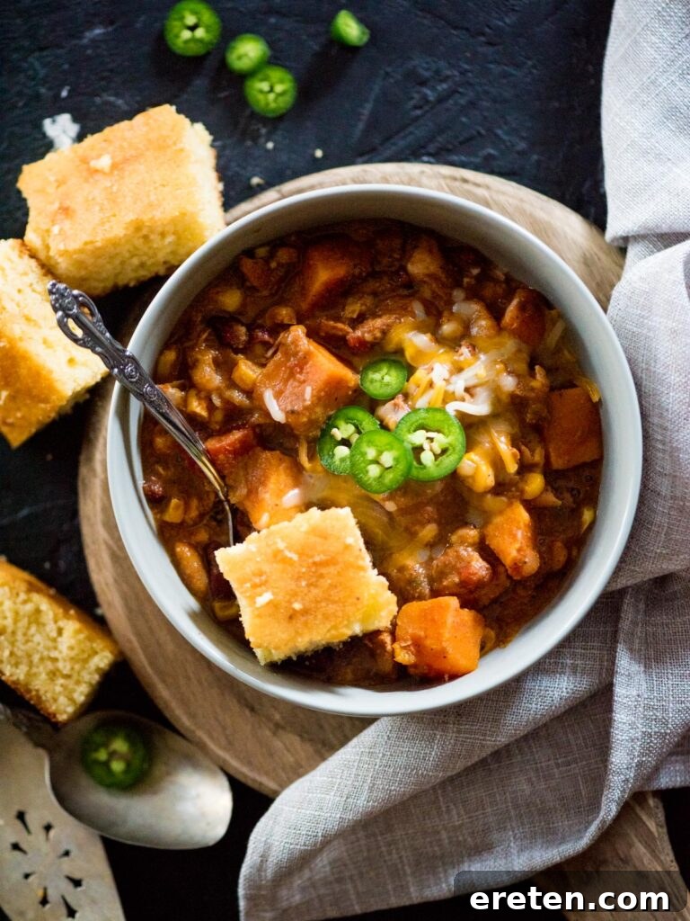 crockpot chicken chili in a bowl topped with cornbread and jalapenos