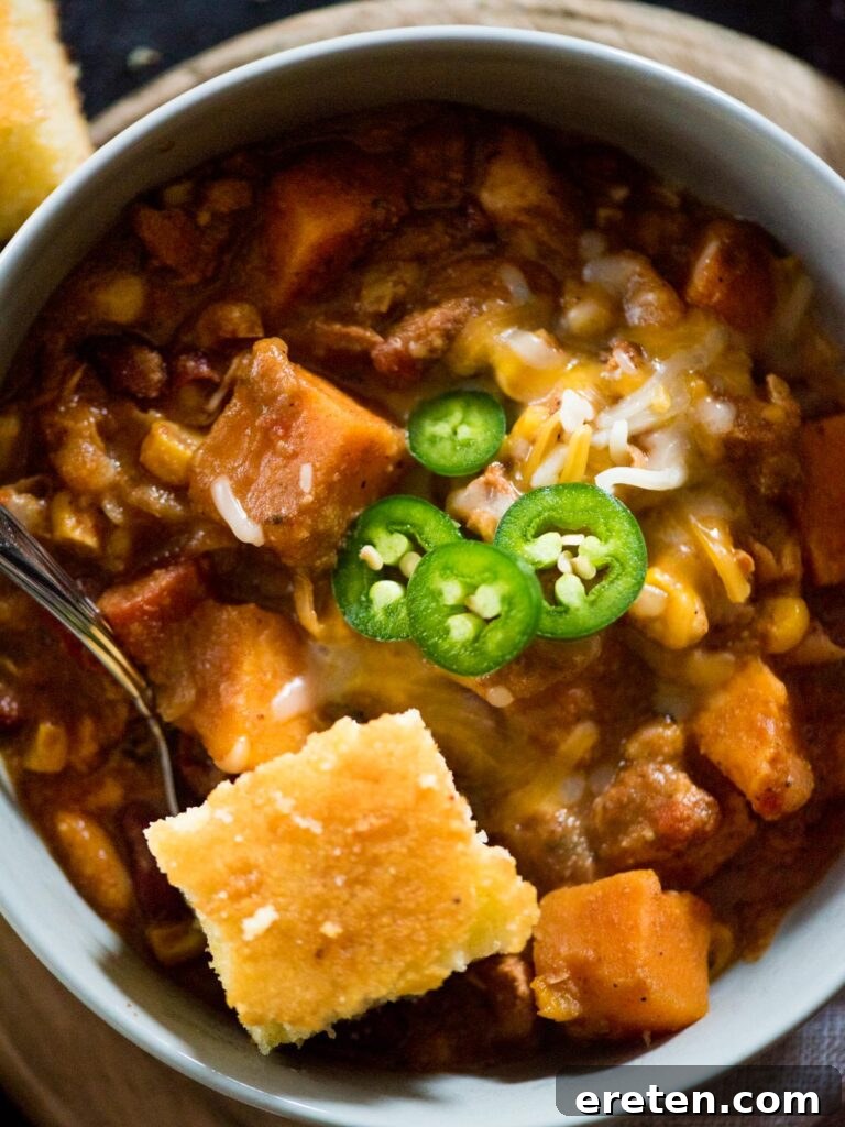 crockpot chicken chili topped with cornbread and jalapeno slices