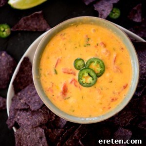 Ultimate Smoked Queso Dip 9 smoked queso in a bowl topped with sliced jalapenos and chips