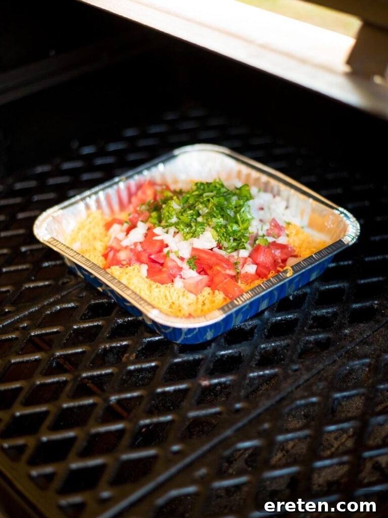 Ultimate Smoked Queso Dip 5 smoked queso dip ingredients in disposable aluminum pan placed on smoker
