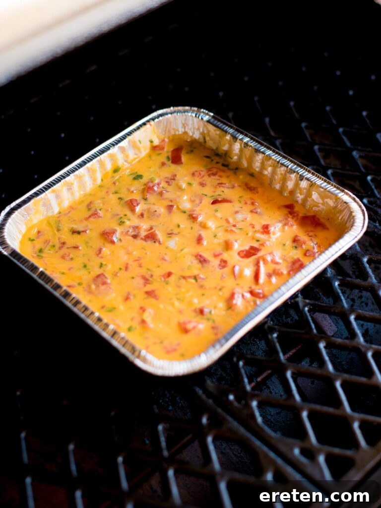 Ultimate Smoked Queso Dip 6 smoked queso dip in aluminum pan that has been melted and stirred