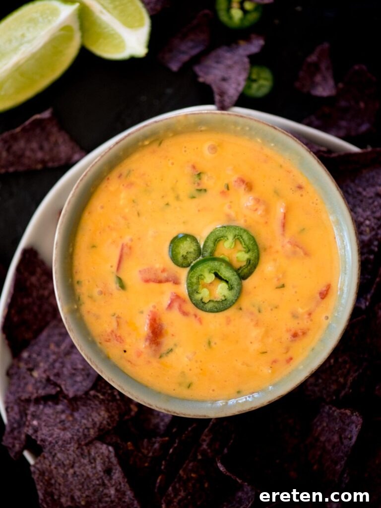Ultimate Smoked Queso Dip 8 smoked queso in a bowl topped with sliced jalapenos and a chip