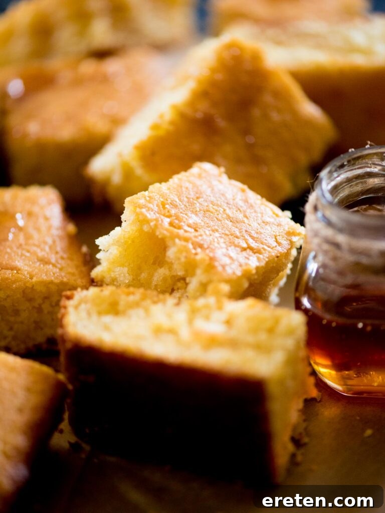 Beautifully cut cornbread squares, elegantly arranged and drizzled with honey