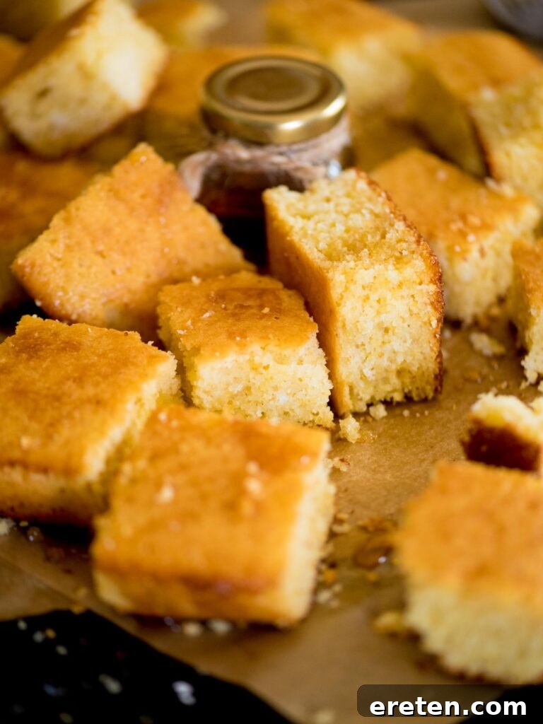 Close-up of freshly baked cornbread, cut into squares and generously drizzled with golden honey, emphasizing its soft texture