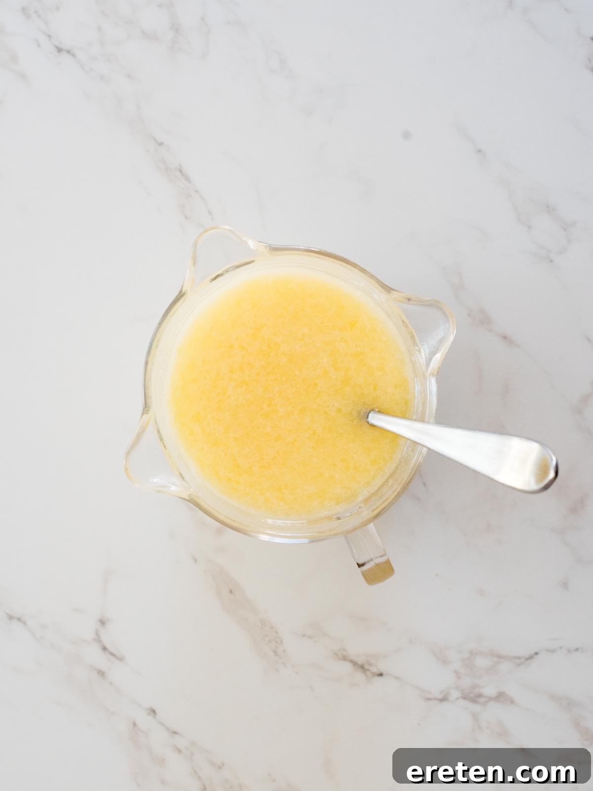 Wet ingredients including melted butter, milk, oil, and eggs are whisked thoroughly in a separate bowl